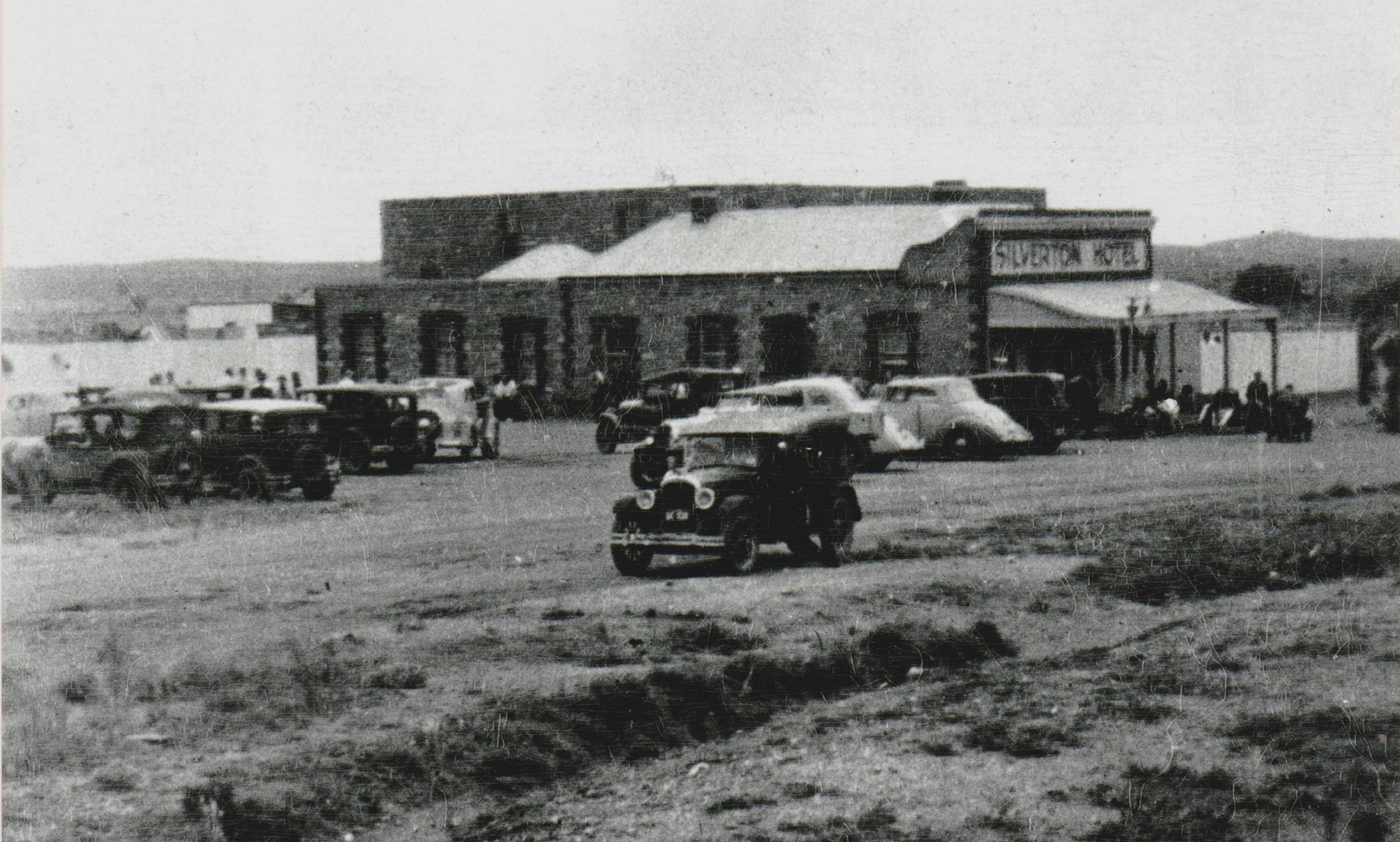 Old cars driving by the Silverton Hotel