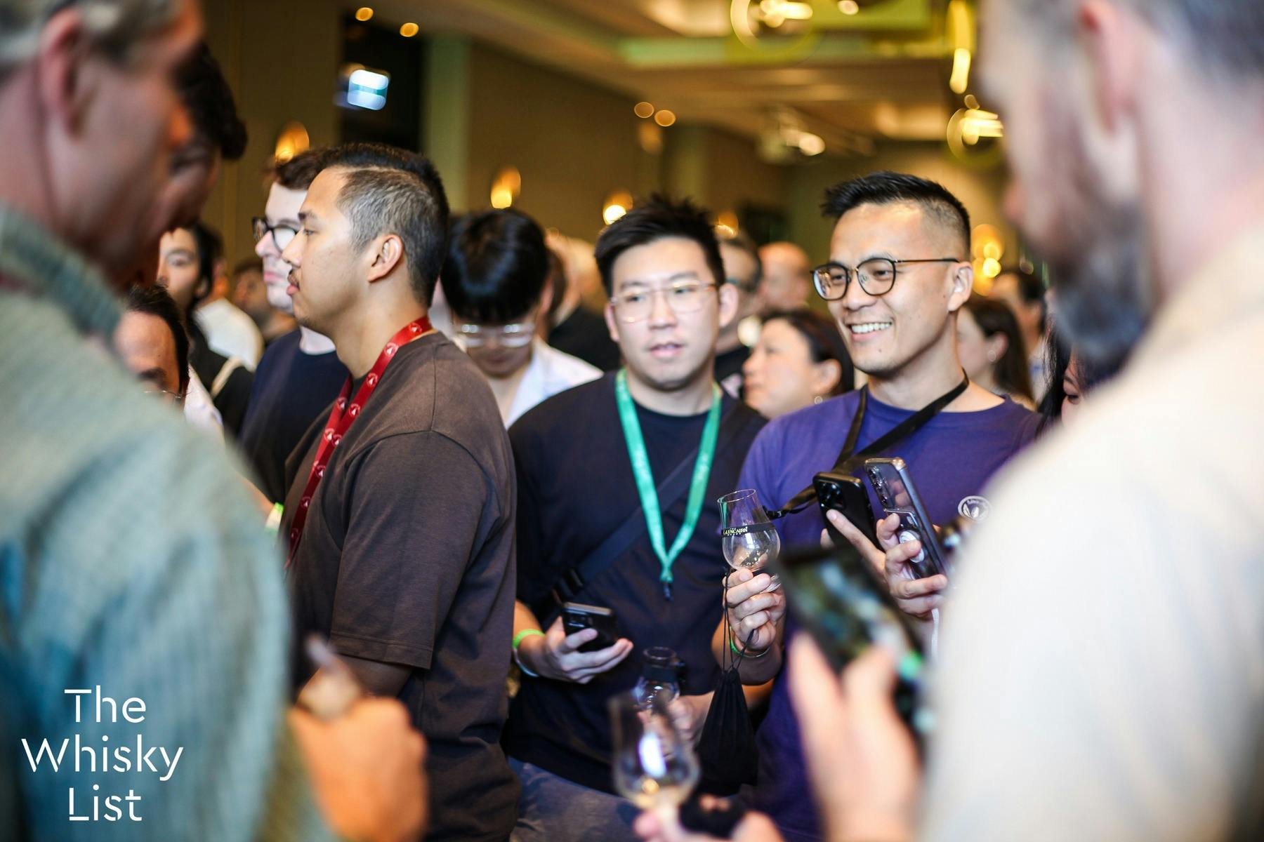 A crowd gathers with empty tasting glasses, hoping to try something from a popular stall-holder