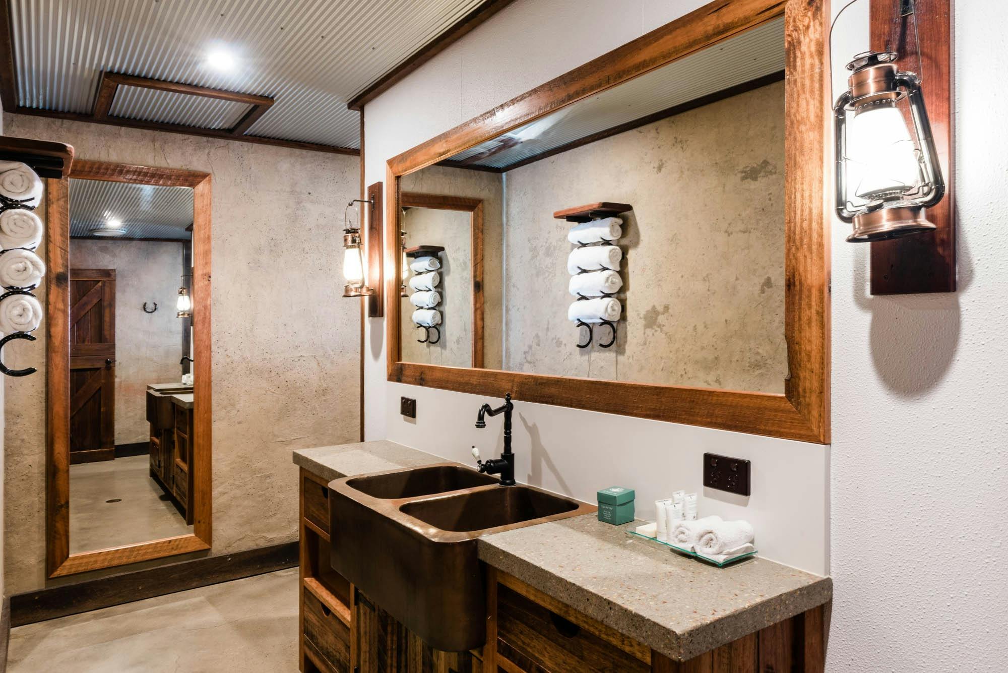Rustic bathroom with oil lamps and brass tap/basin