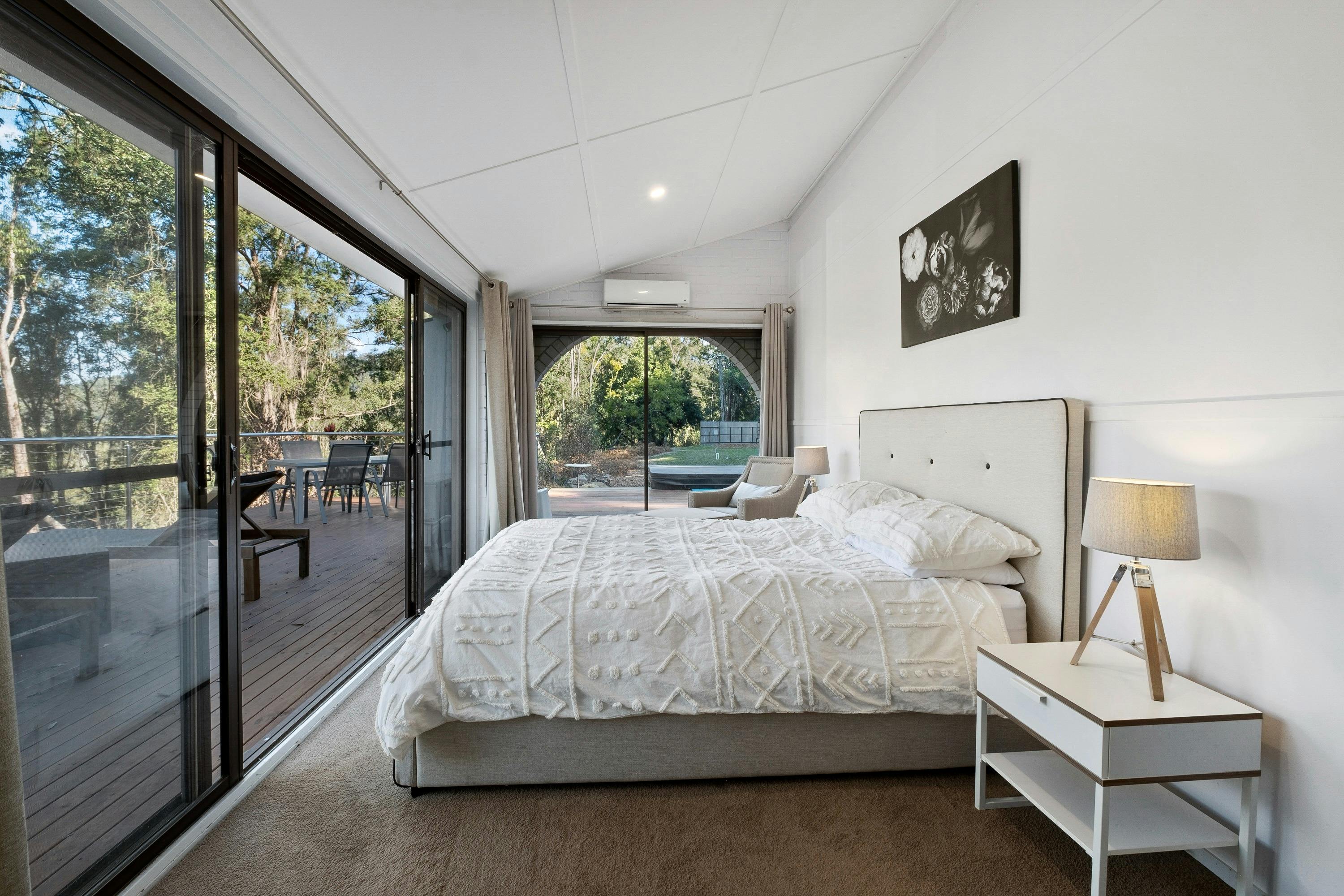 Bedroom interior of White Gum Cottage with a balcony overlooking the surrounding natural landscape.