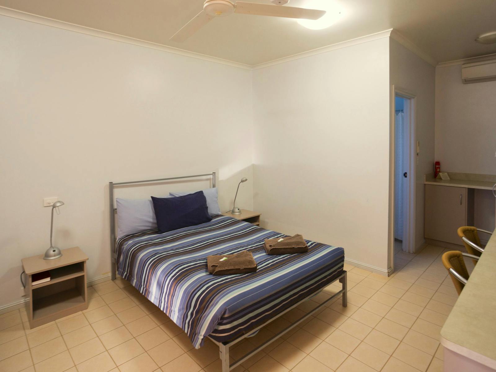 Motel-style room with bed, bedside table at Birdsville Hotel