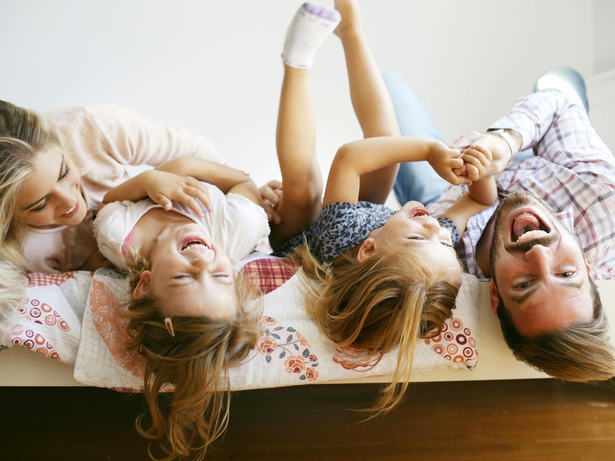 Family laughing on bed
