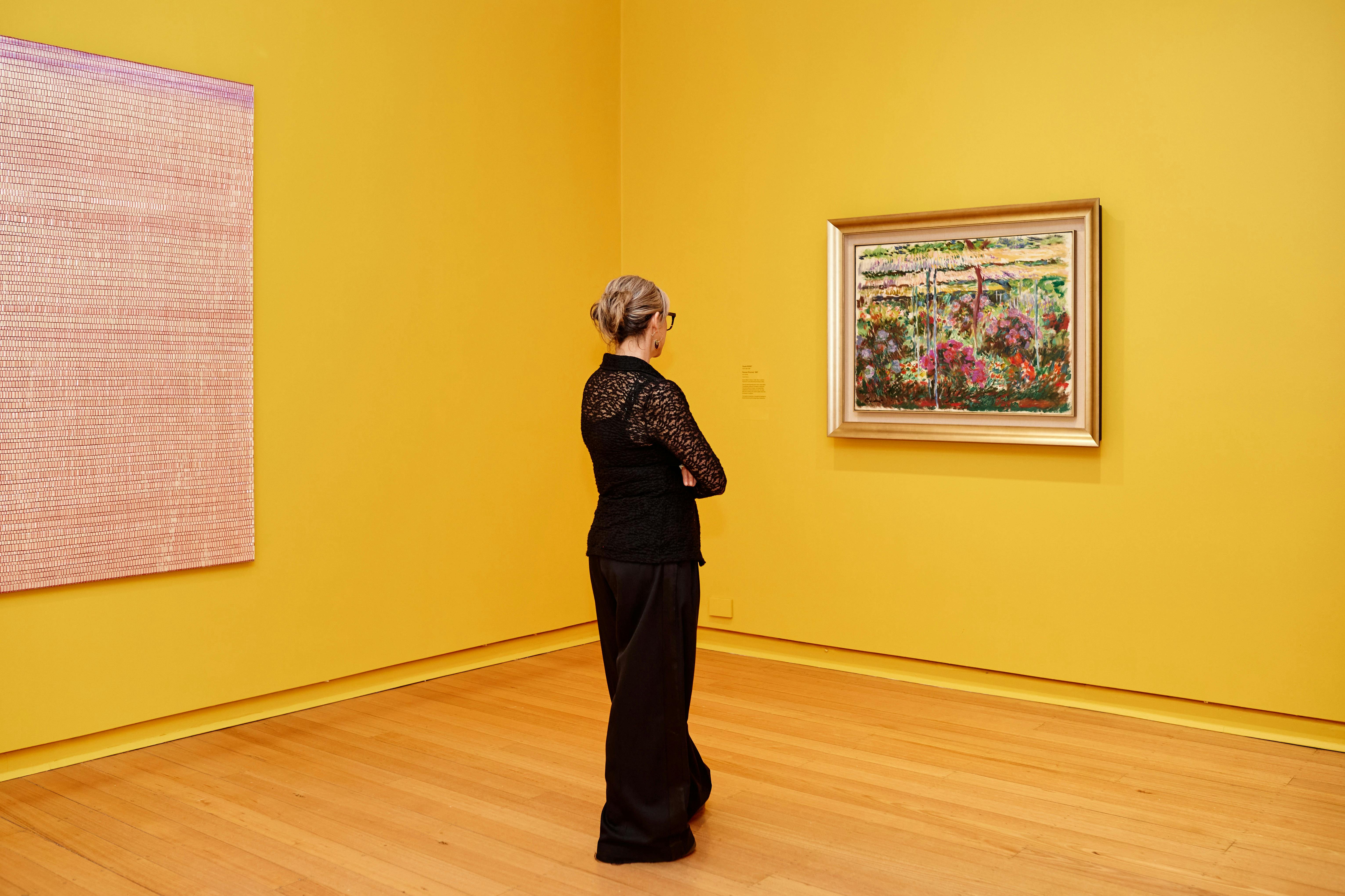Visitor looking at an Impressionist artwork in gallery