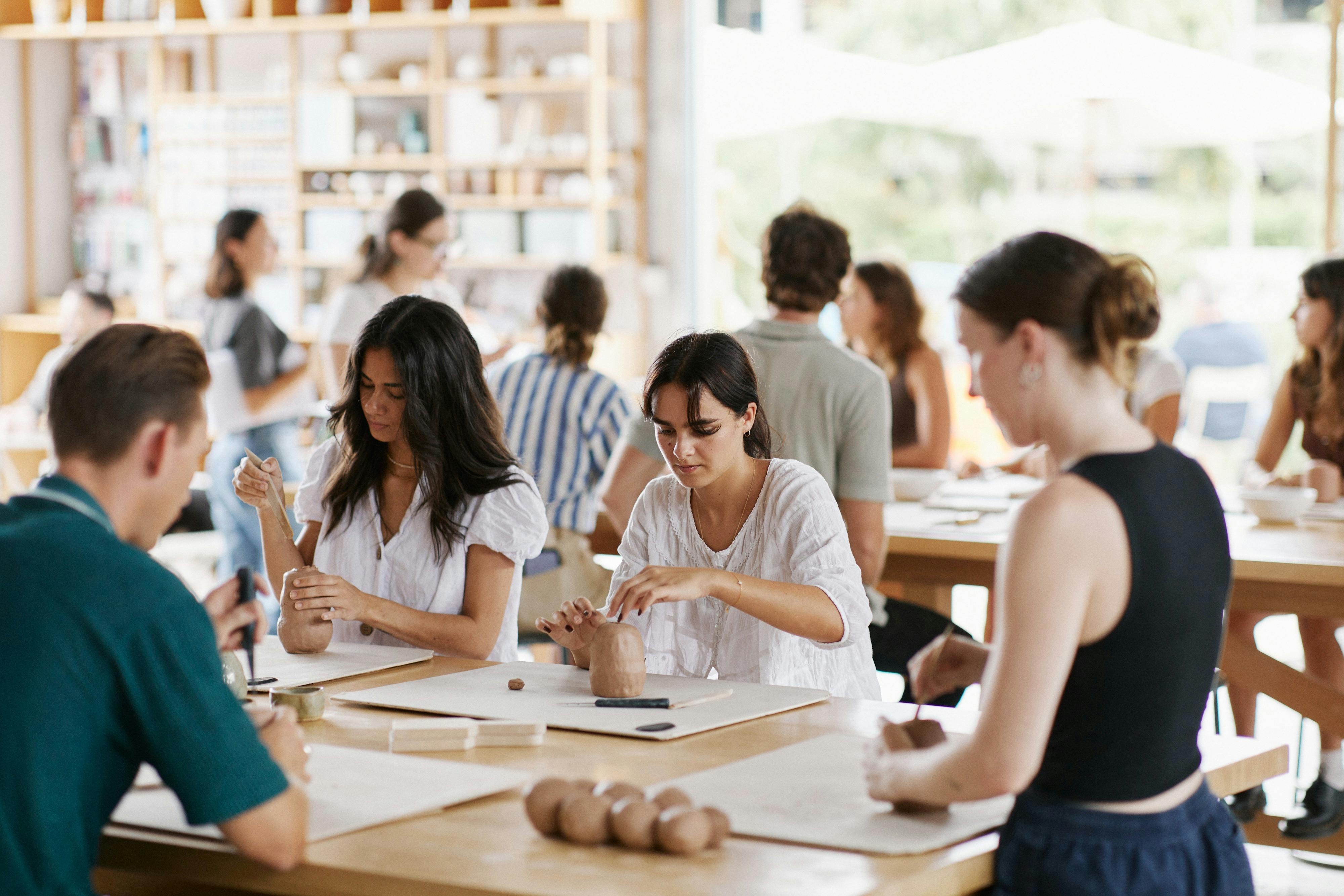 Adults working with clay at a Crockd Studios class