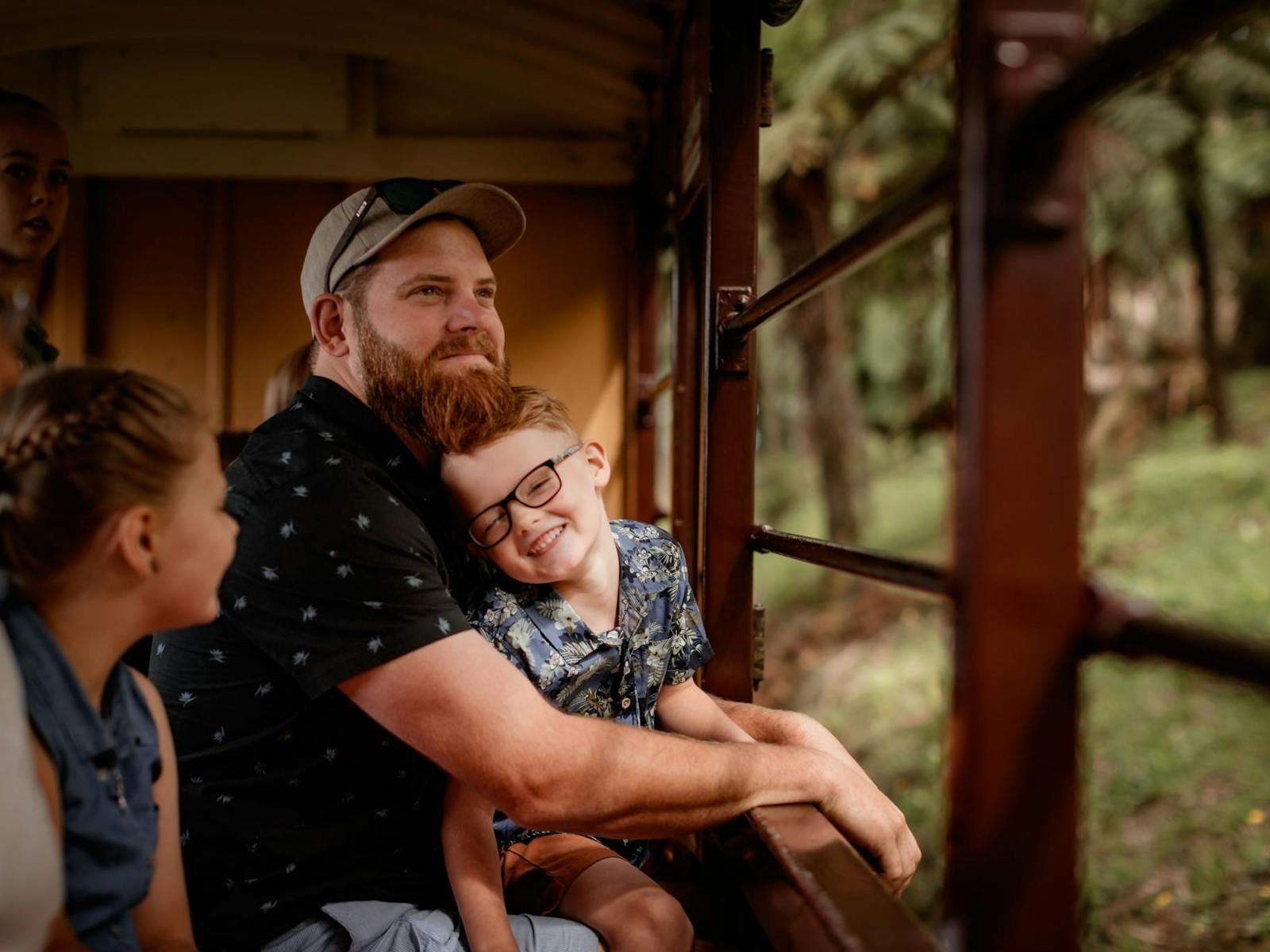 Father and son sitting and looking at views of forest