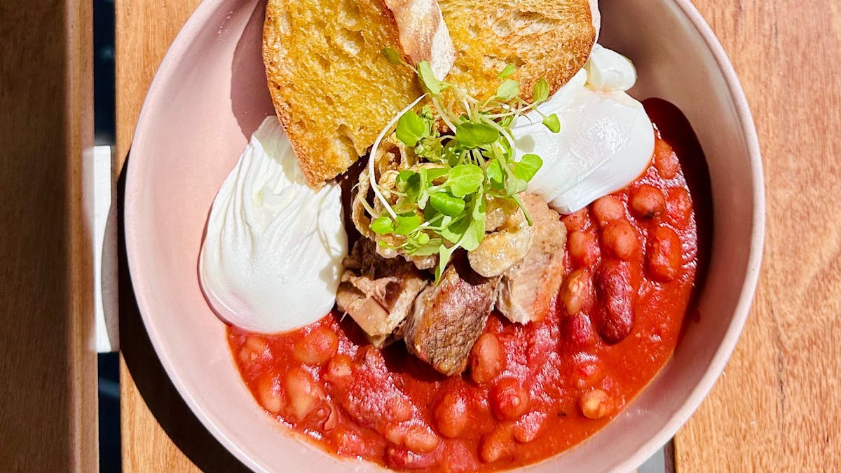 Confit pork belly, puffed skin, spiced beans, poached eggs, and rustic