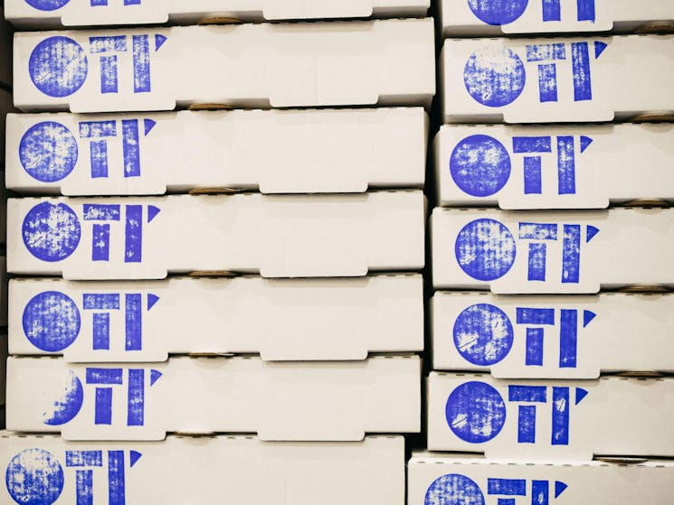 Stacked Oti' pizza boxes