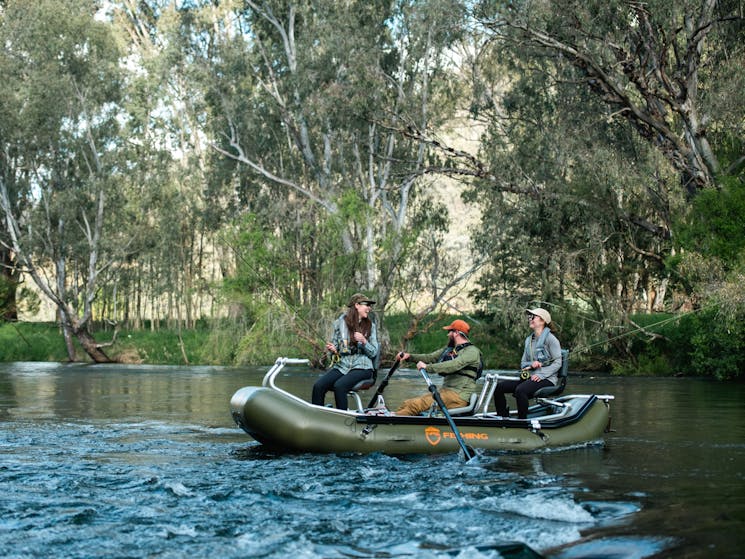 Fly fishing for trout on a drift boat on the the Tumut river in the Snowy Mountains
