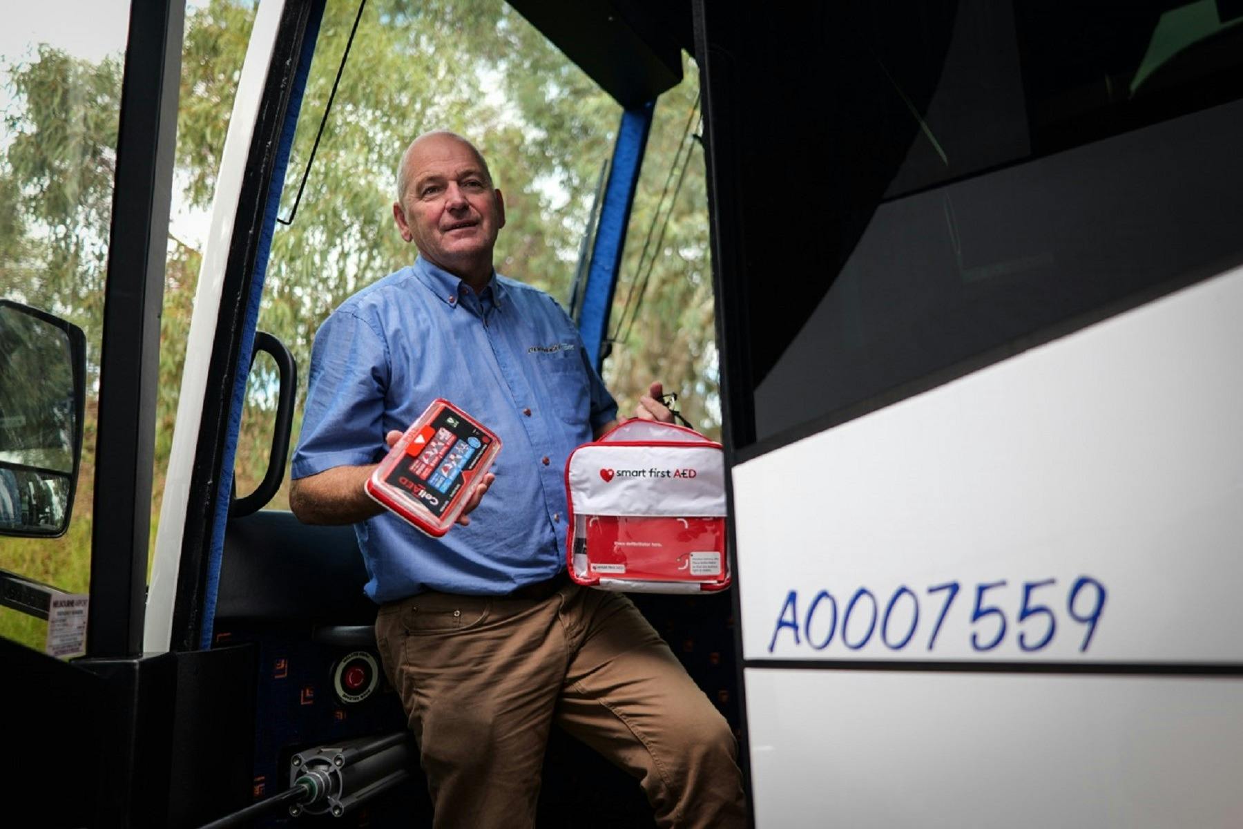 Owner holding a defibrillator installed on all coaches