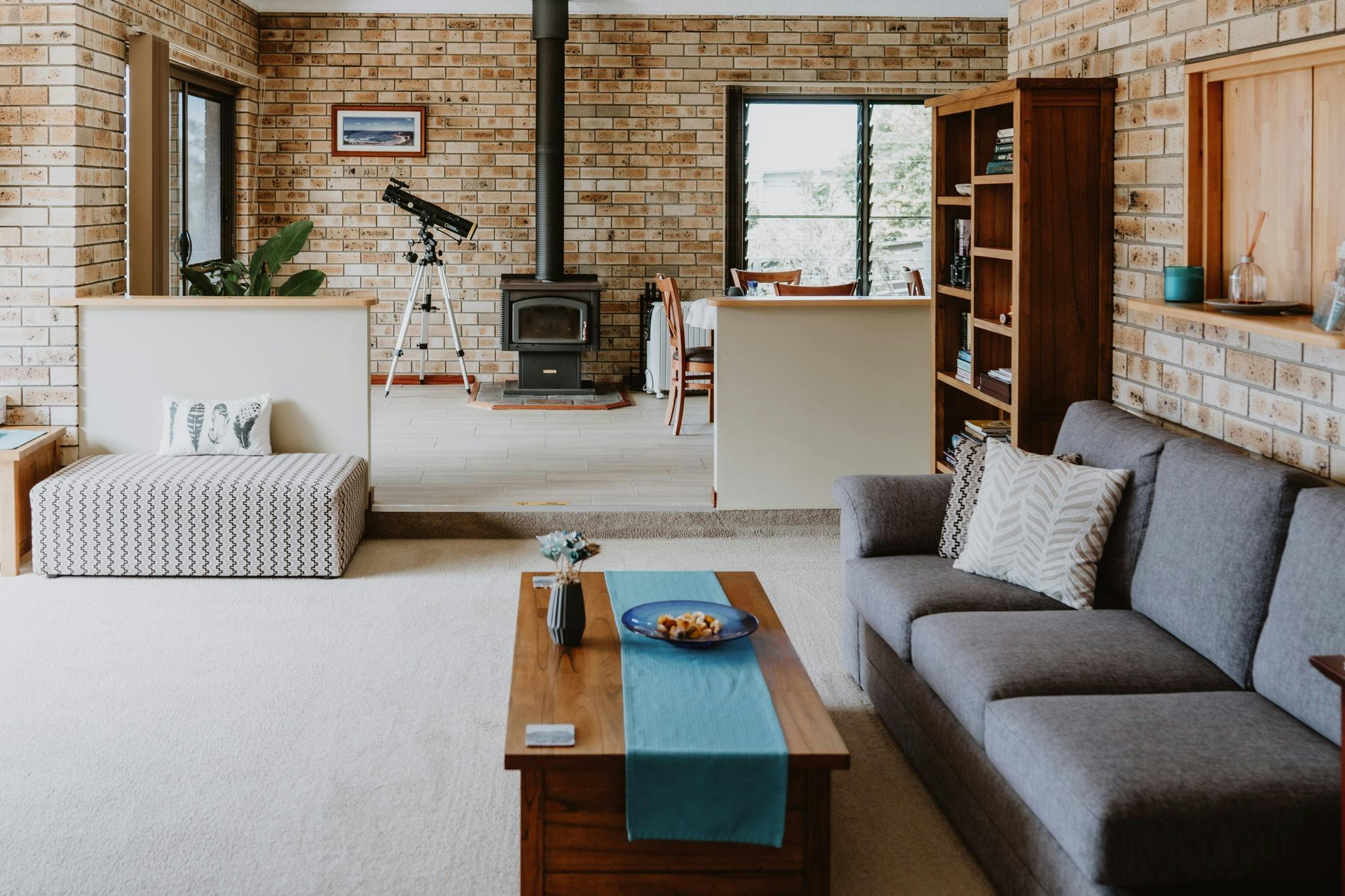Common area lounge room with lounge and coffee table in foreground, library, to fireplace at rear