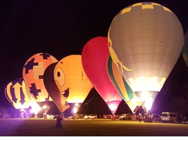 Glowing hot air balloons in night sky