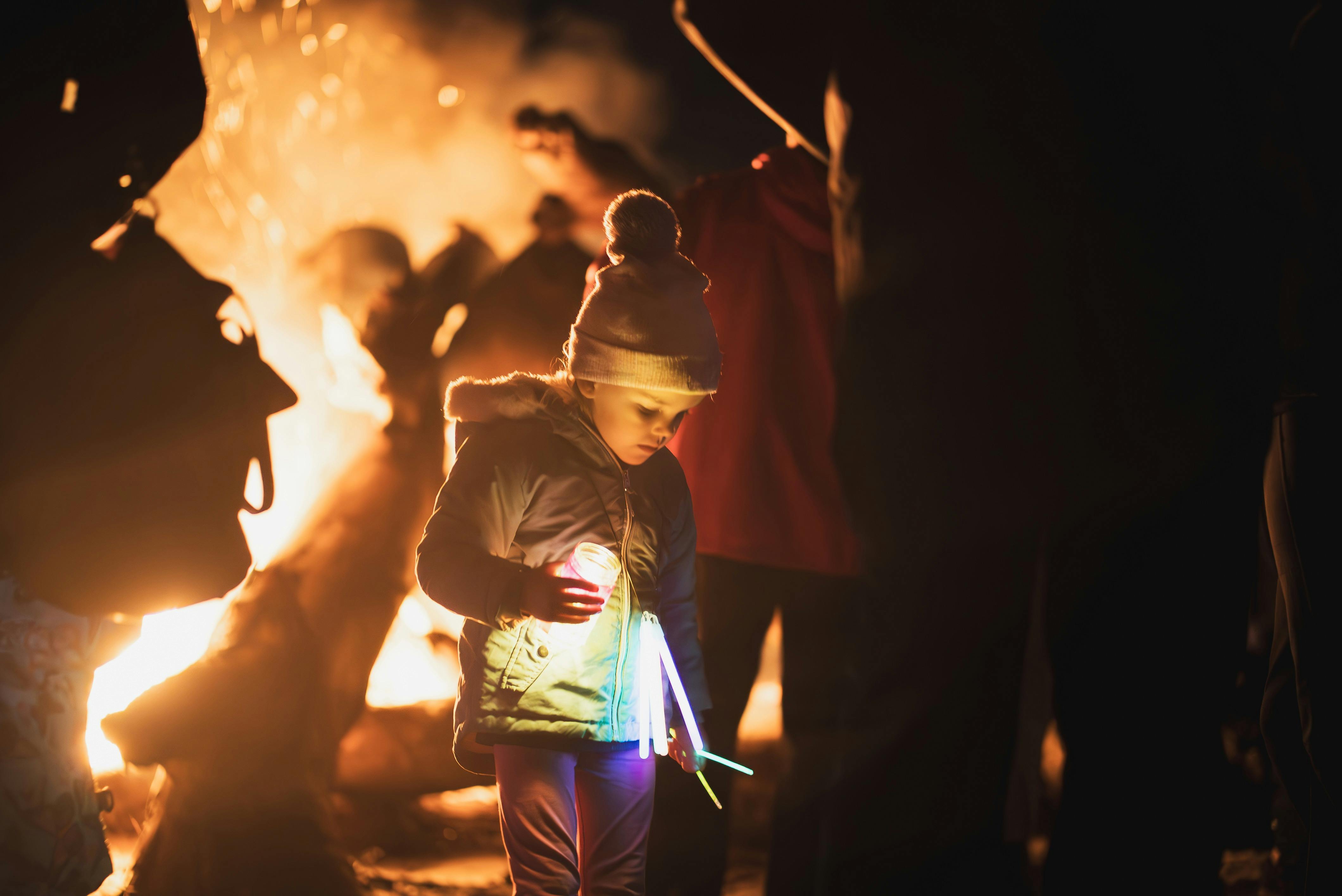 Child with glow art next to the bonfire
