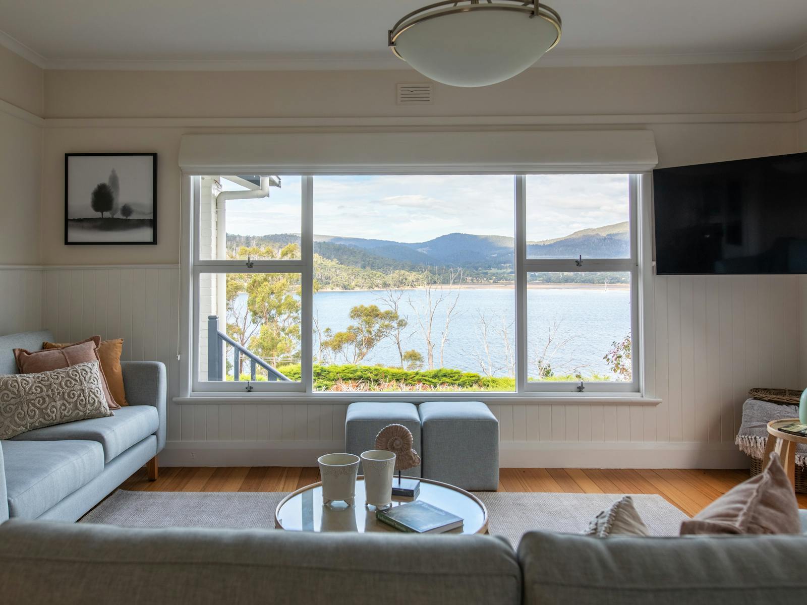 Image of a living room with a couch, tv and view over the bay