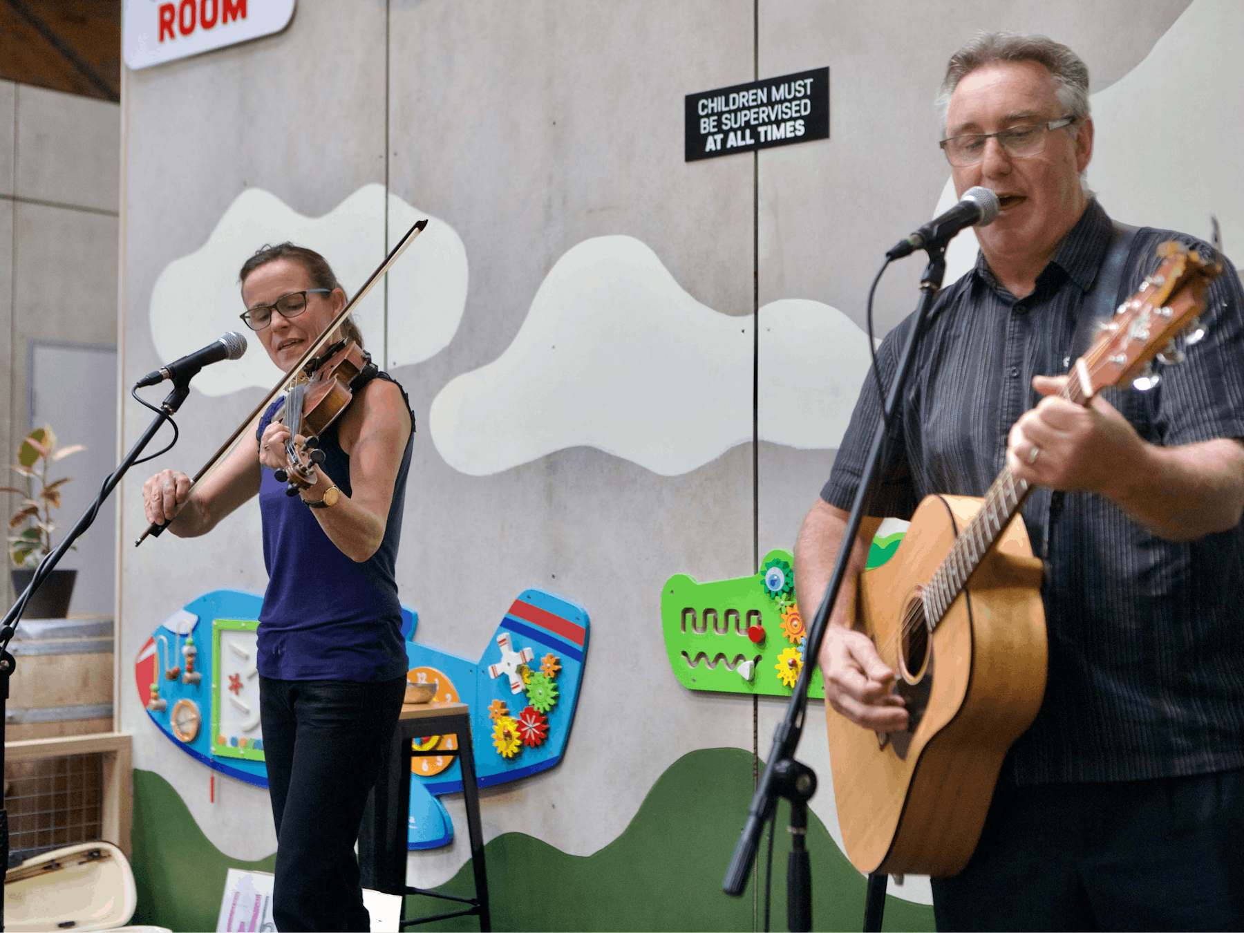 Female violinist and male guitarist on stage