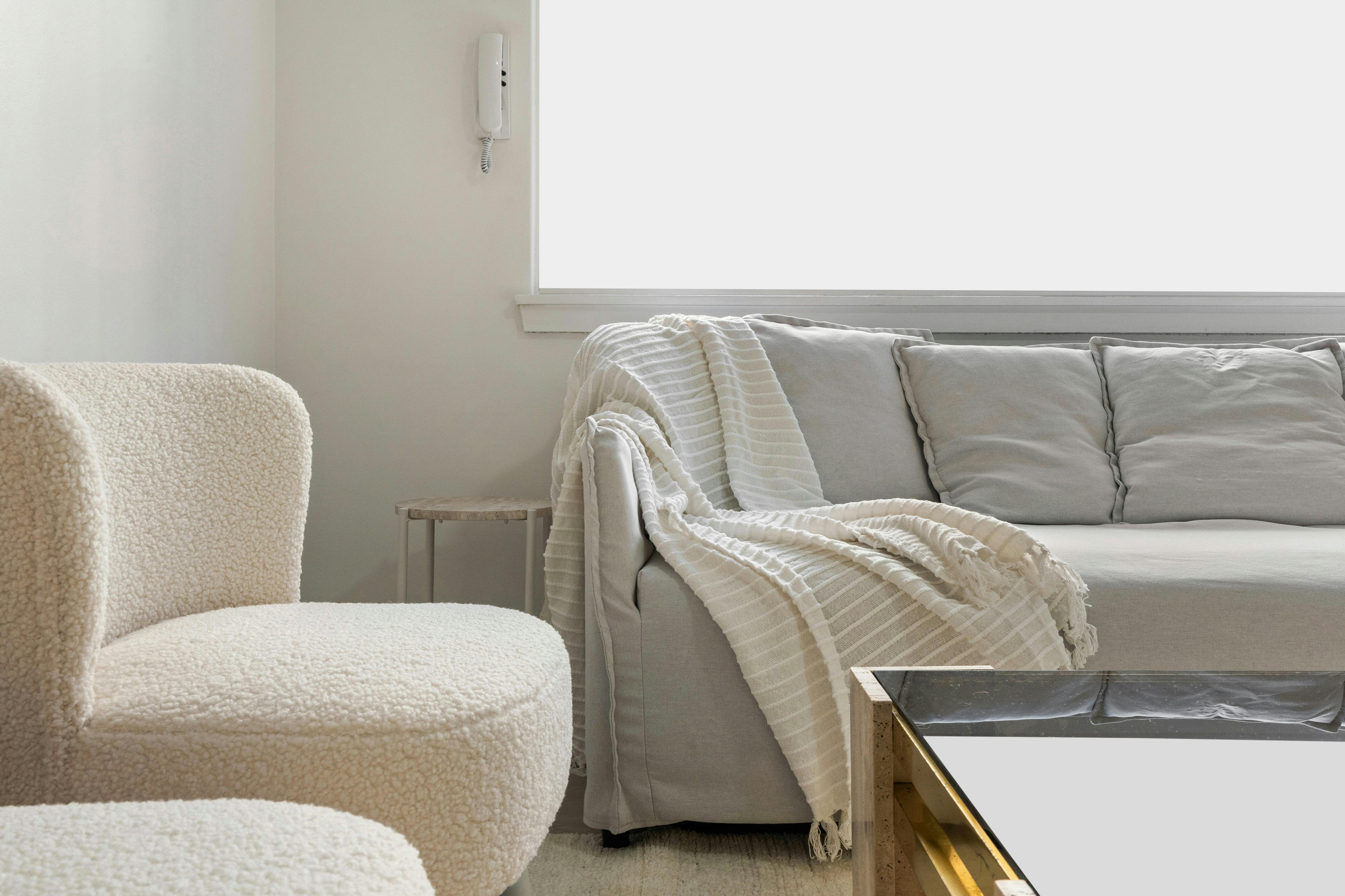 沙發的特寫鏡頭，配有毯子和舒適的椅子。