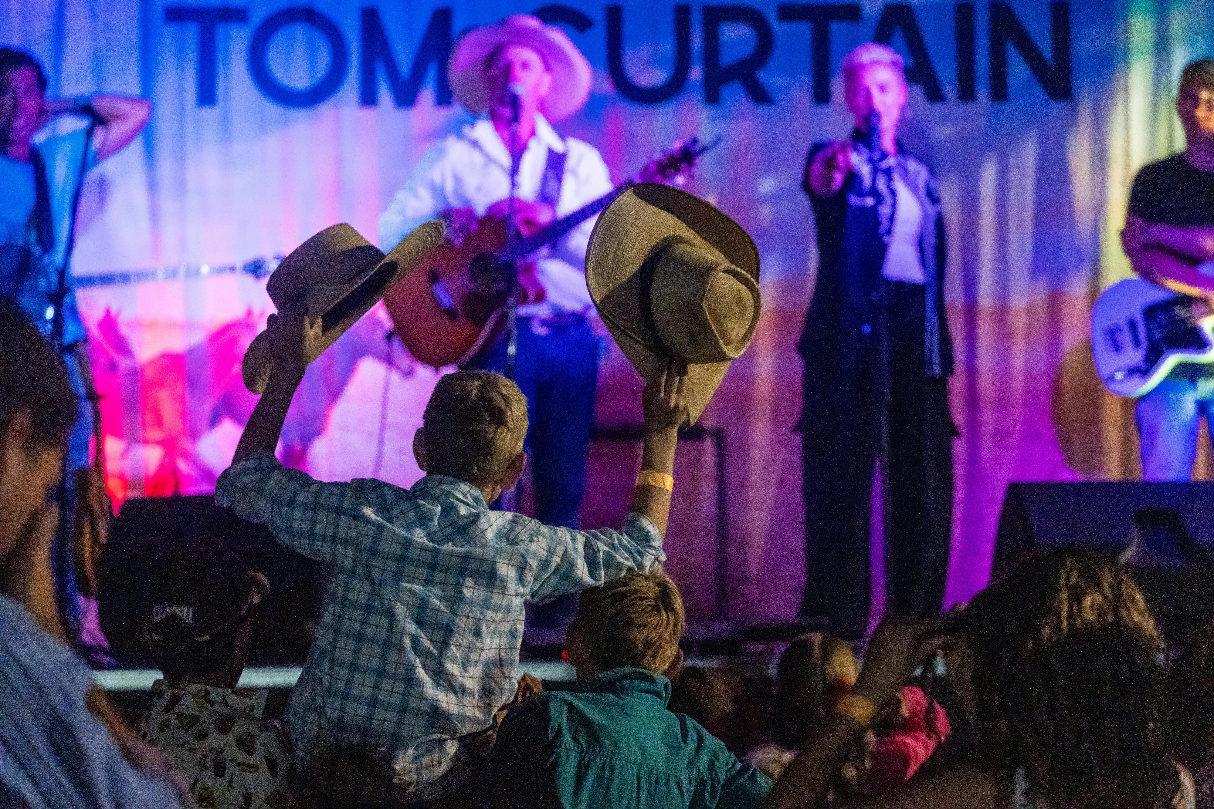 Tom Curtain performing on stage to fans