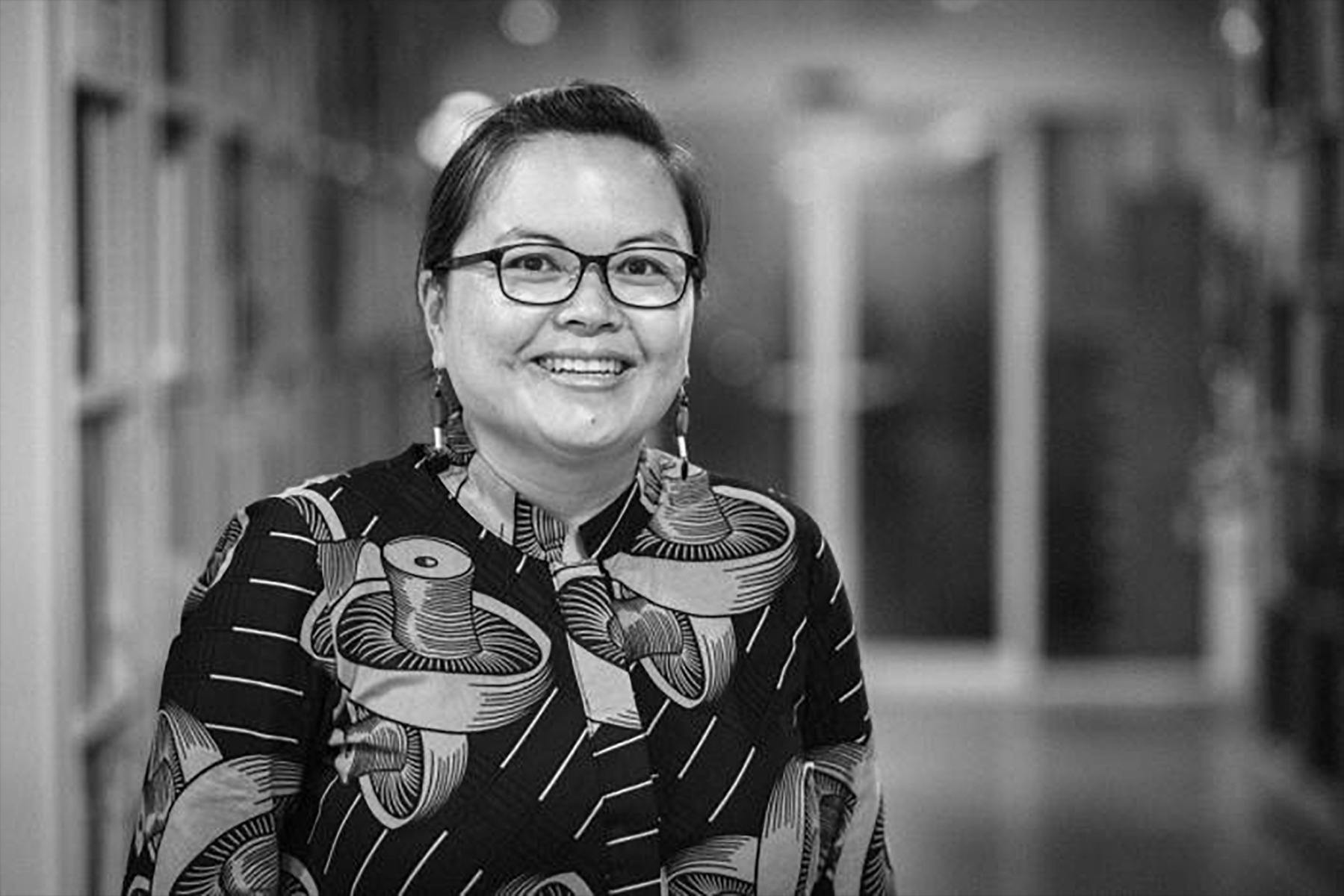 A black and white photo of a woman smiling