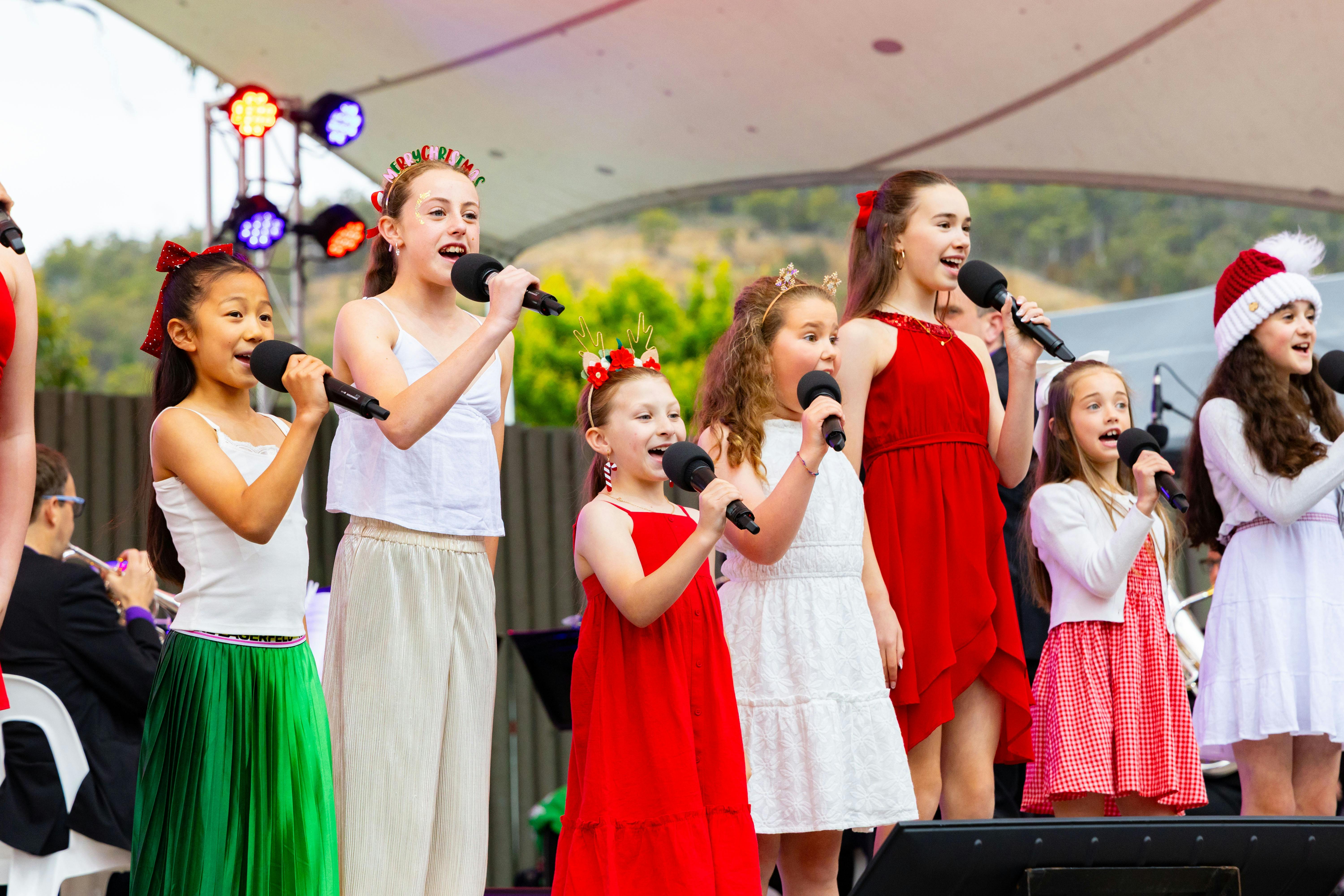young singers in Christmas colours smiling and singing carols