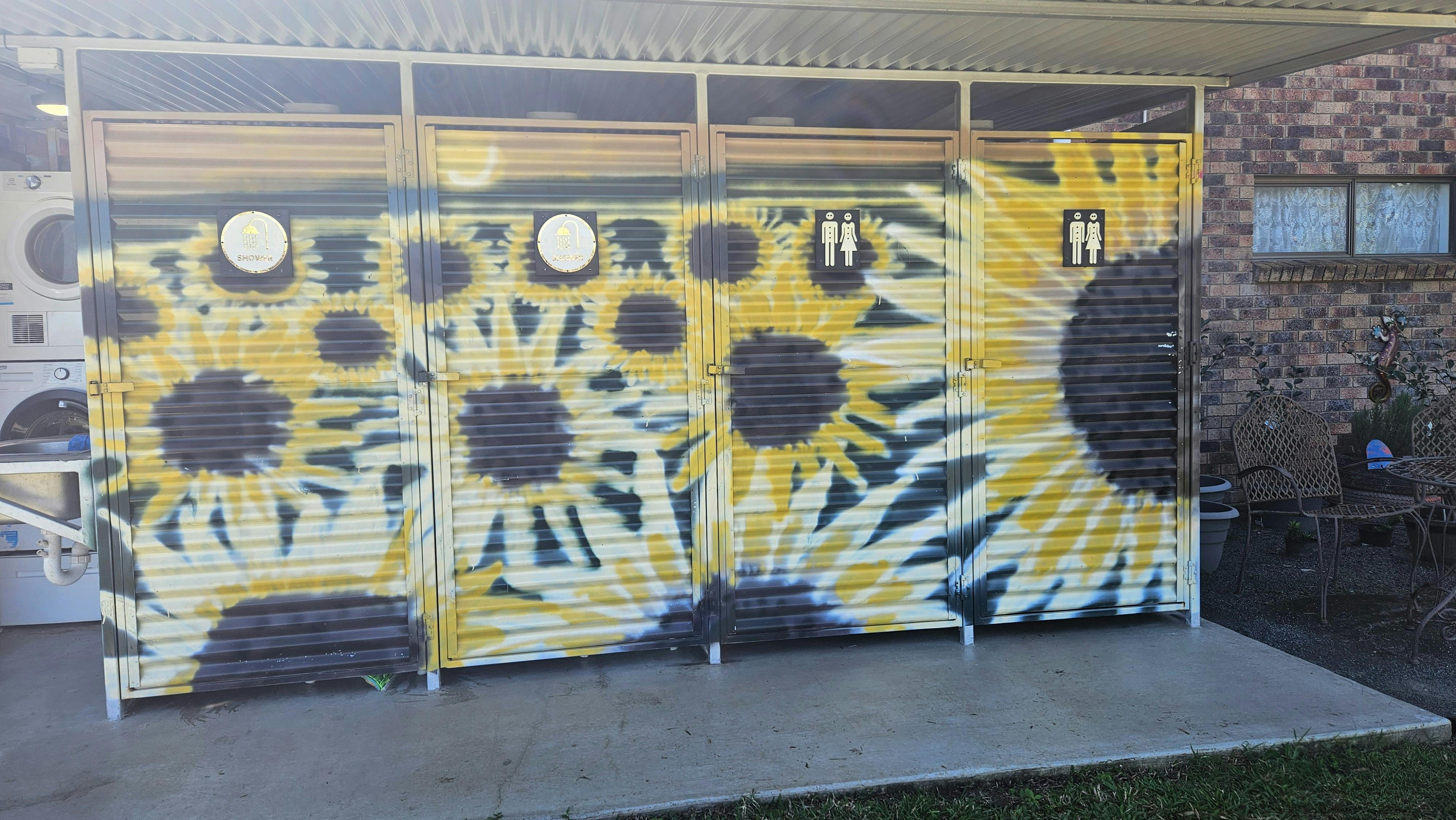 Shower block painted with sunflowers that are at the camping grounds at Oh Deere Famrstay