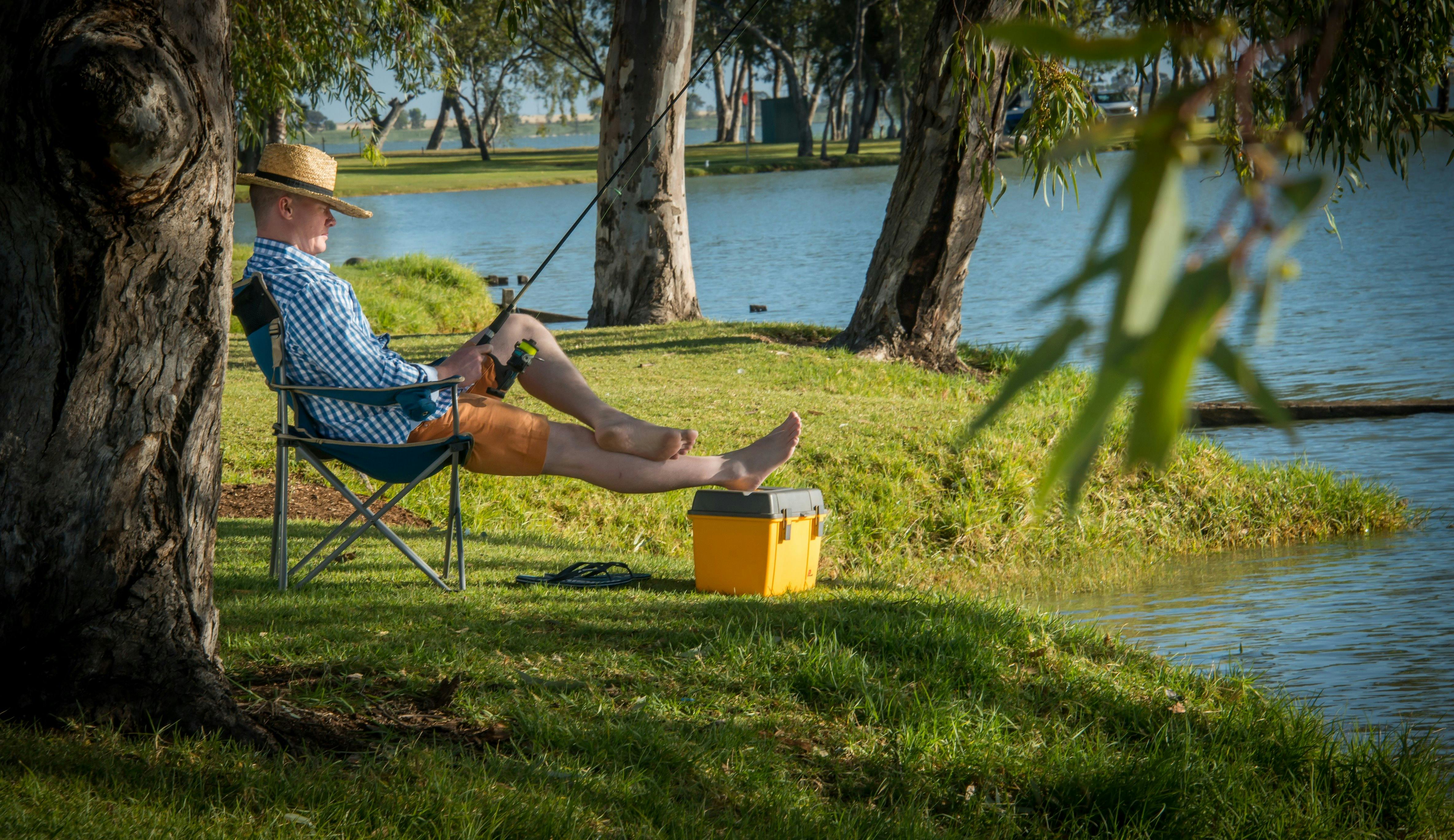 A fisherman relaxing while fishing at Lake Charm