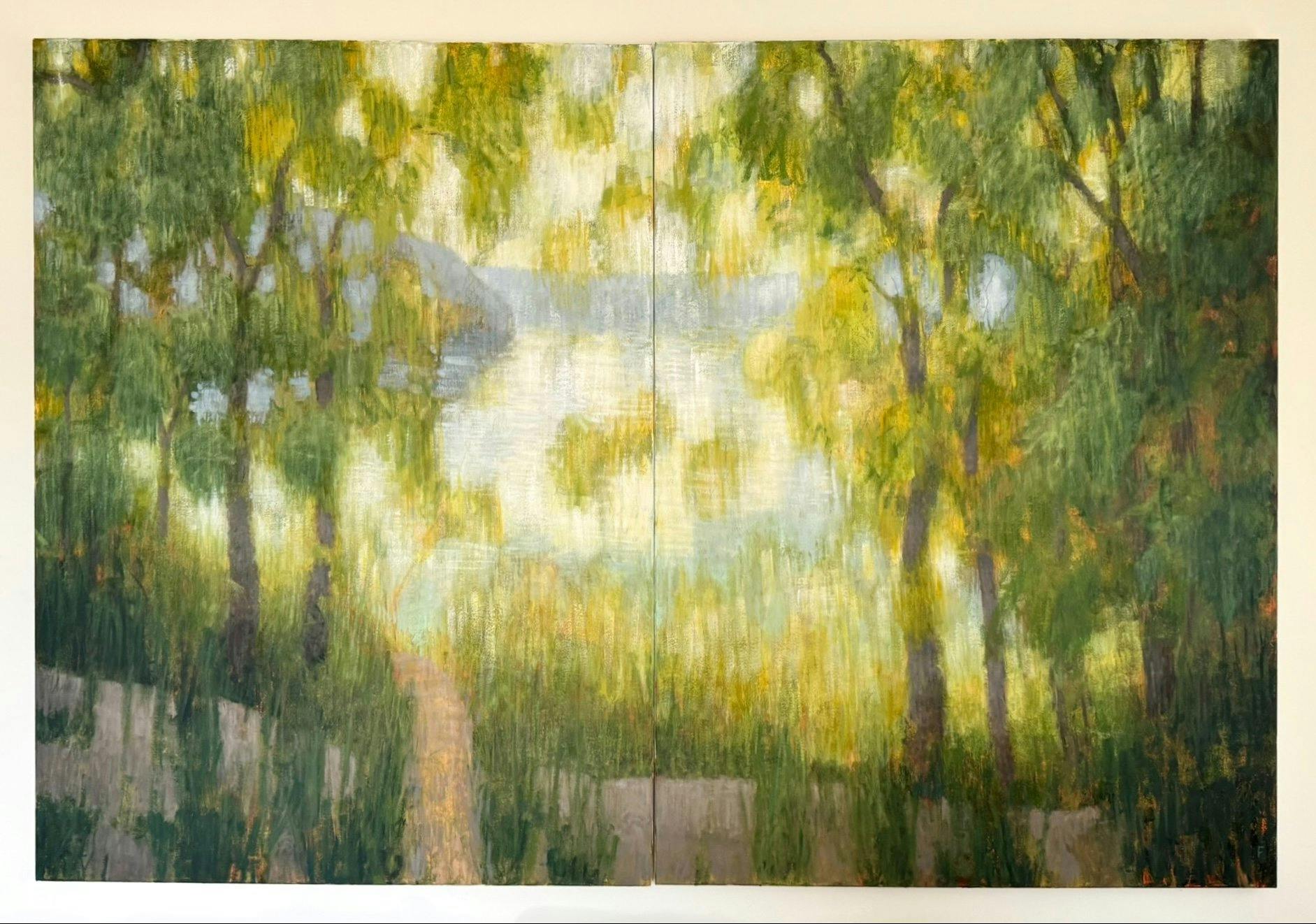 Warm, green, leafy trees partly obstruct a river at dusk, the reflection on the water a pale golden