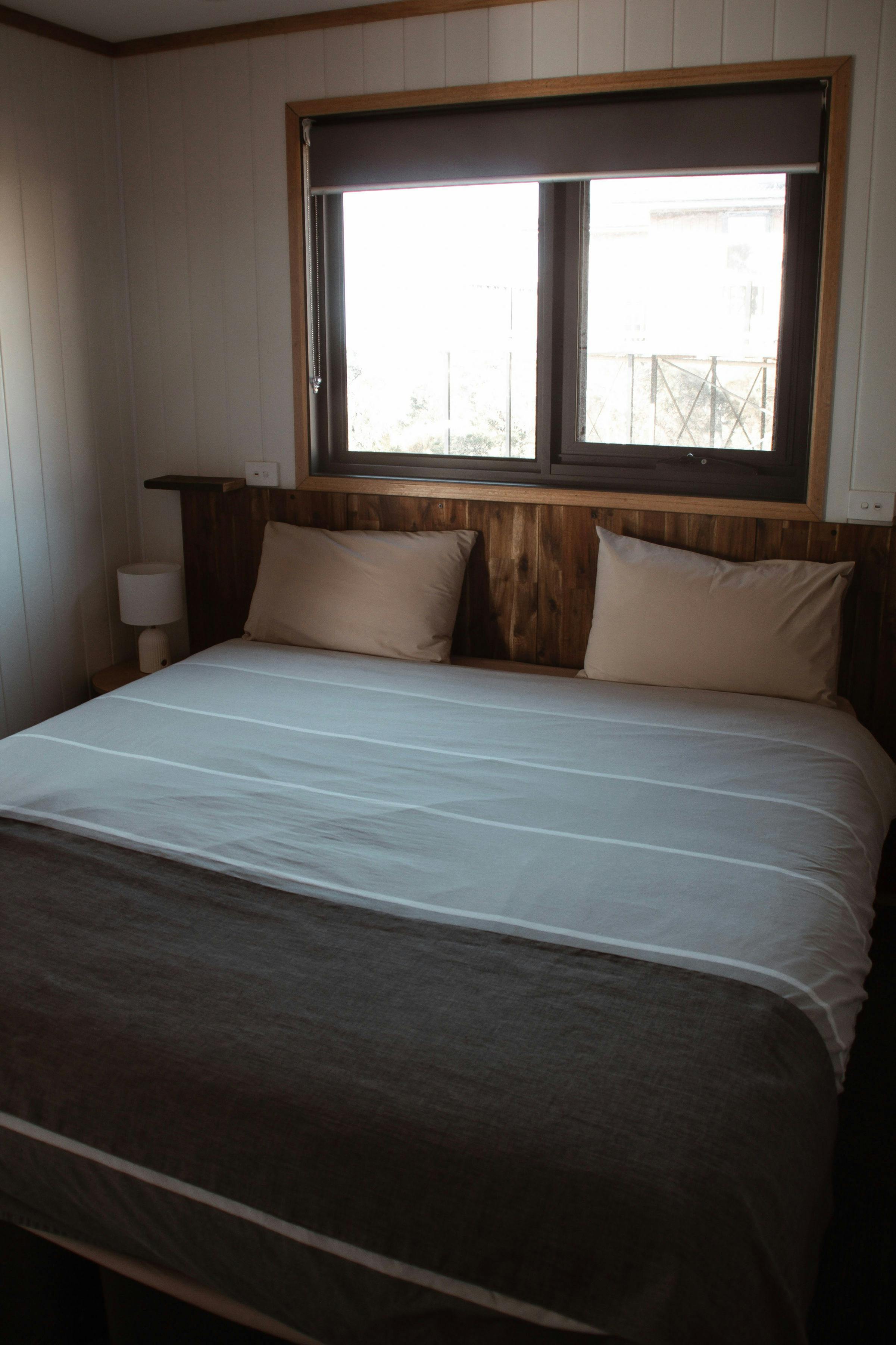 Bedroom with queen bed, bedside tables and views through the window