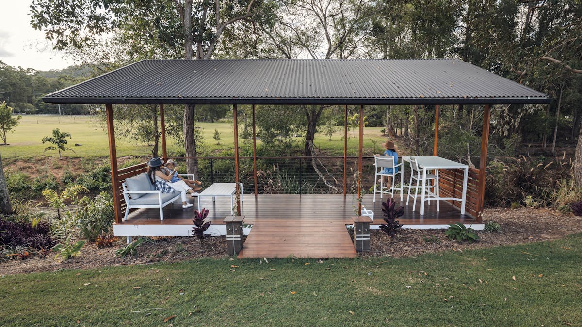 Covered picnic area with lounge and table setting overlooking the duck pond