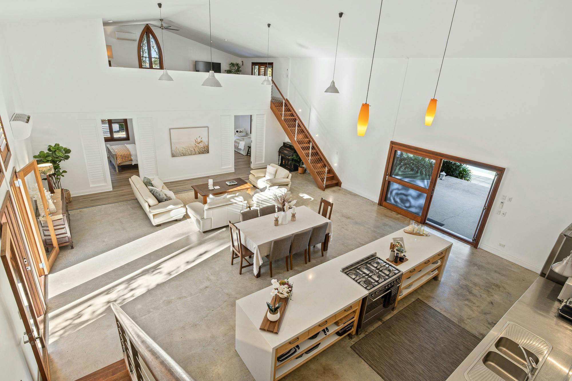Open-plan living and kitchen with modern decor, island bench, cozy seating, and natural light