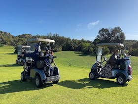 Golfers driving buggies through scenic dunes at Robe Golf Club on the Limestone Coast coast.