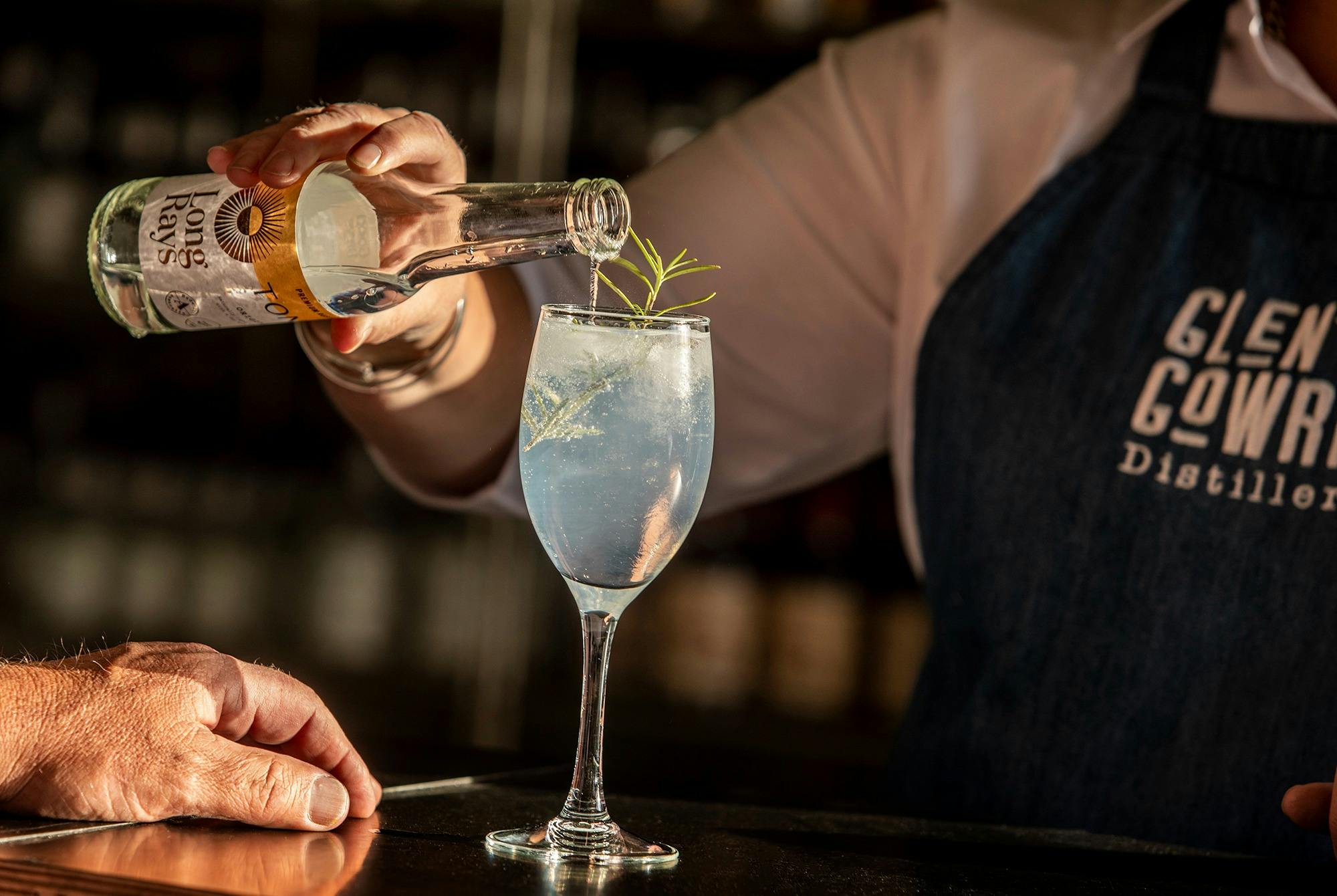 Gin and tonic being poured into a glass