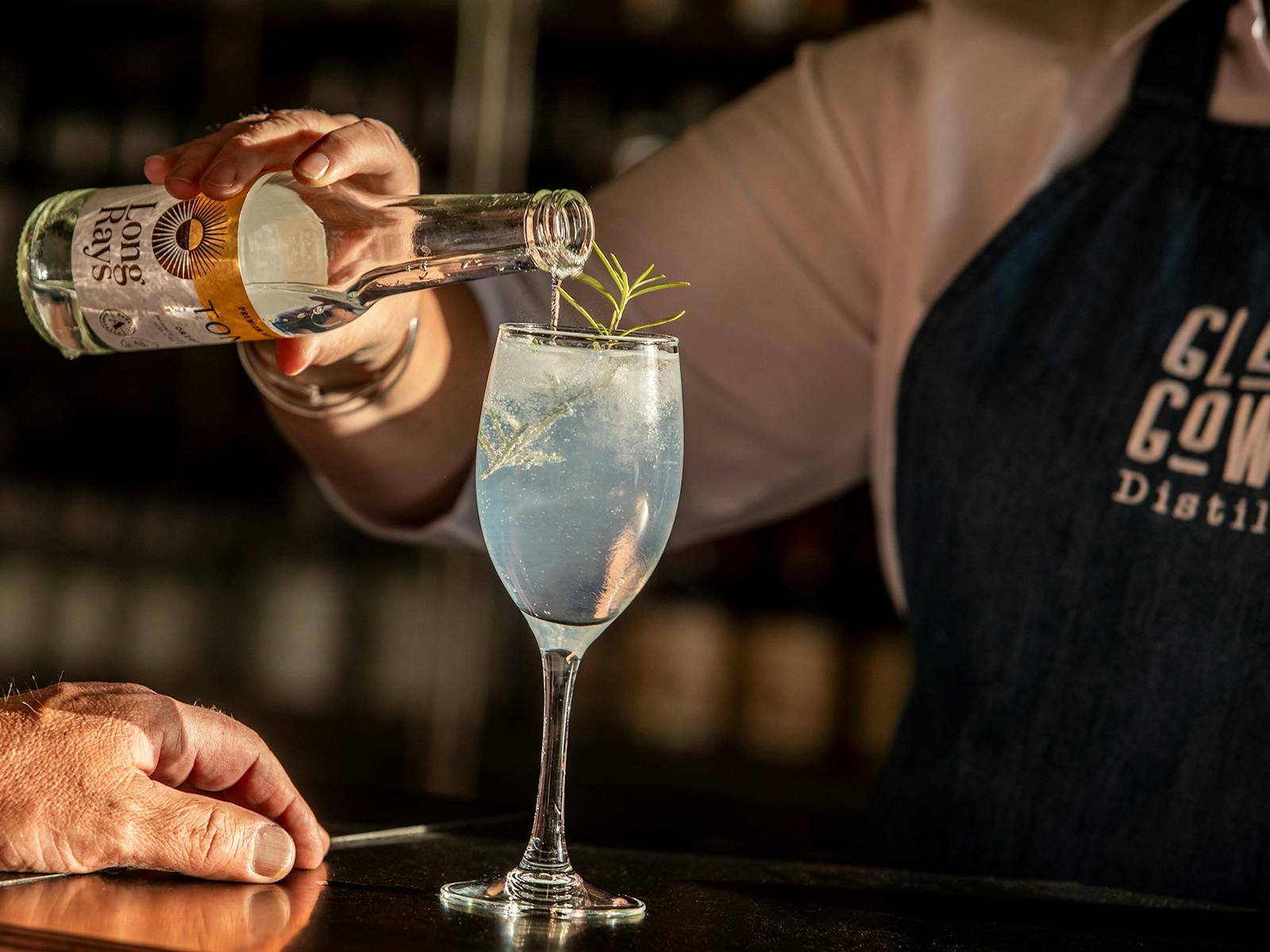 Gin and tonic being poured into a glass