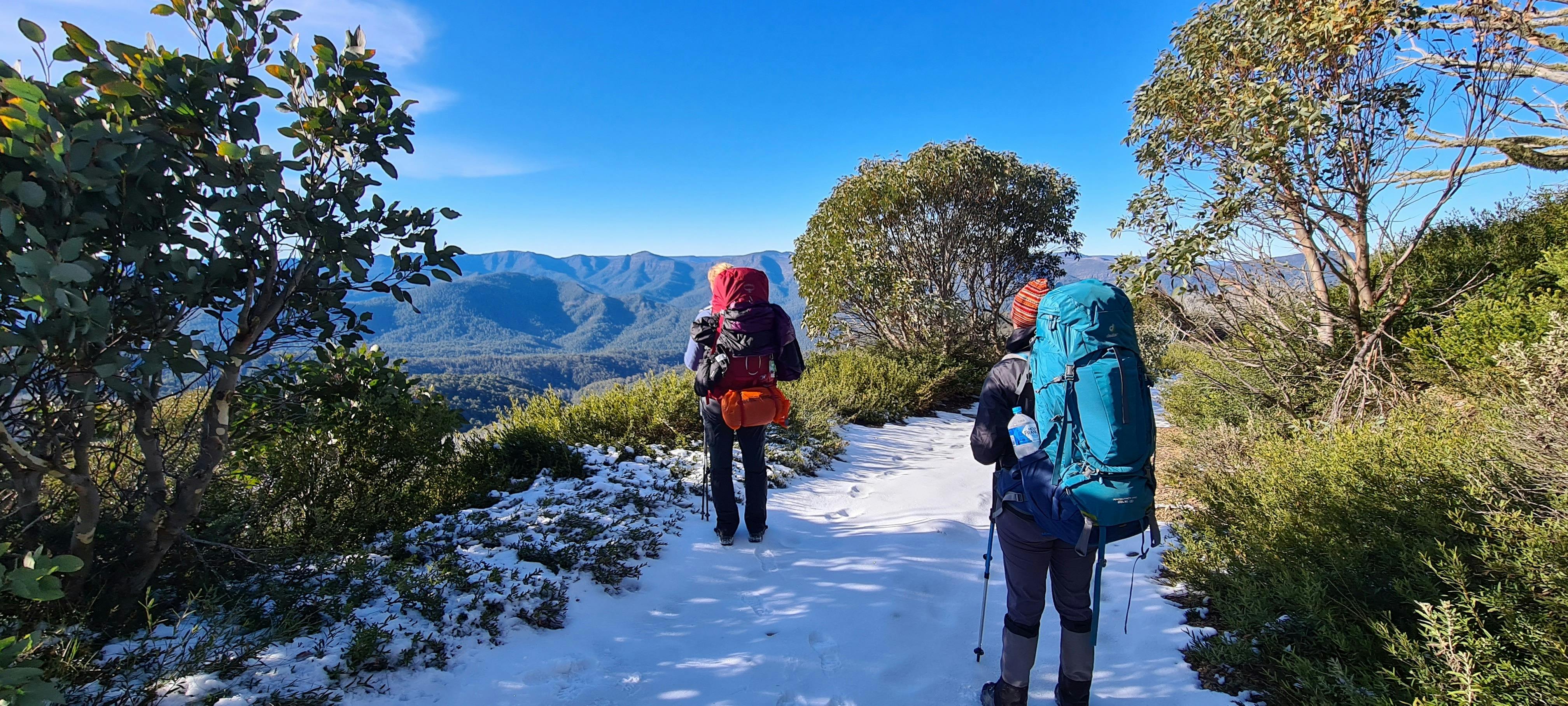 Hiking on a snow covered trail on a bluebird day enjoying views of the surrounding mountains