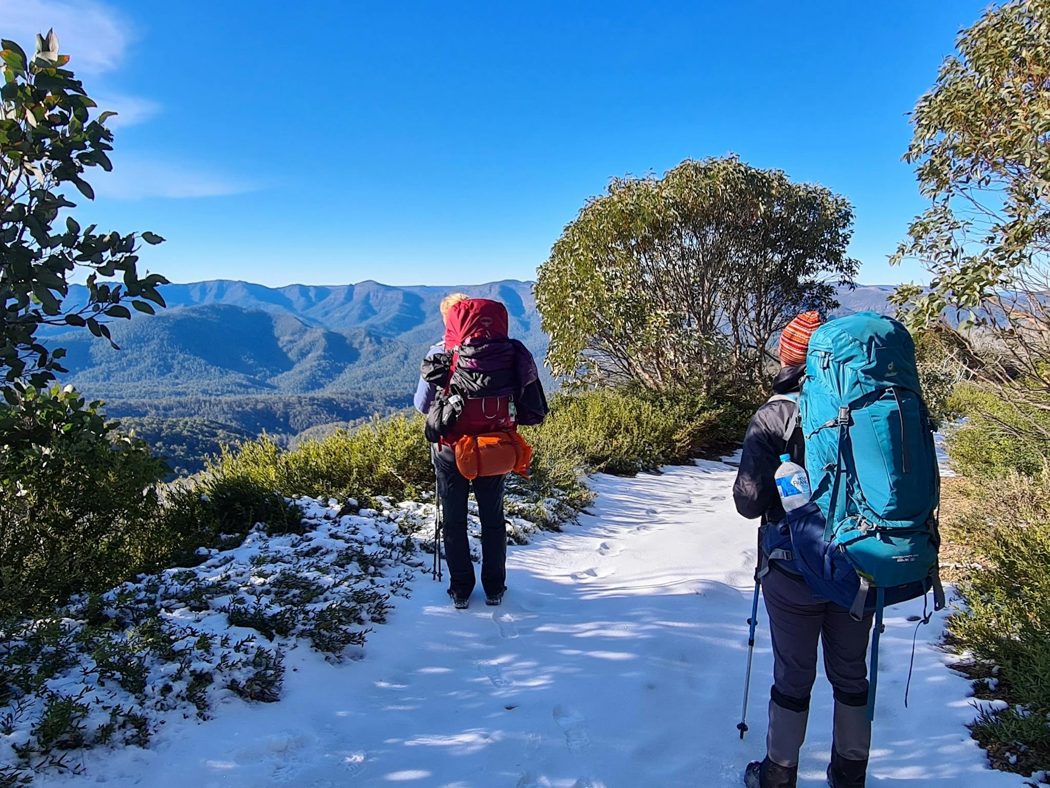Hiking on a snow covered trail on a bluebird day enjoying views of the surrounding mountains