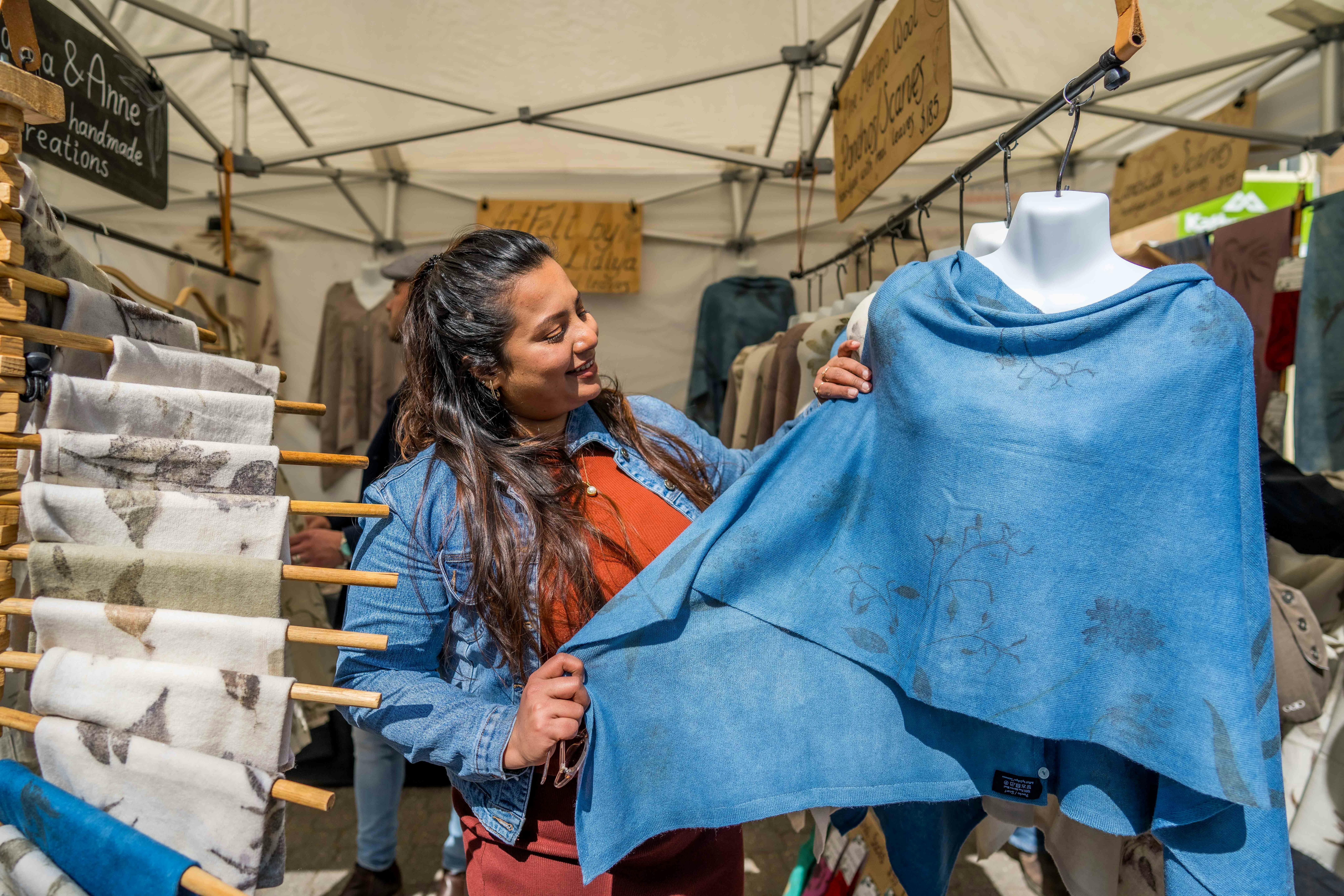 A girl admires at a handmade blue shawl