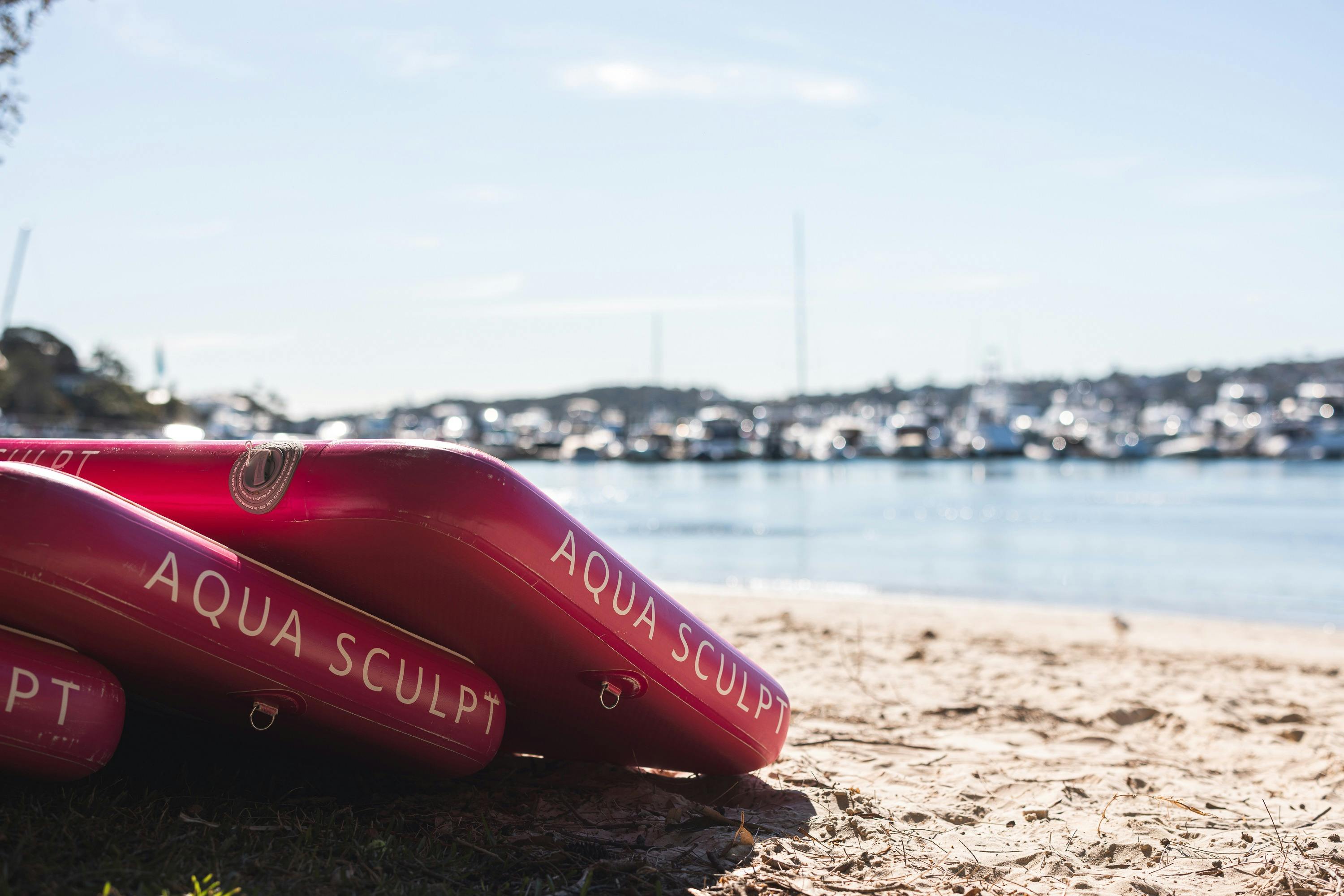 로즈 베이의 벨라미 비치 모래 위에 기대어 있는 두 개의 아쿠아 스컬프트 보드