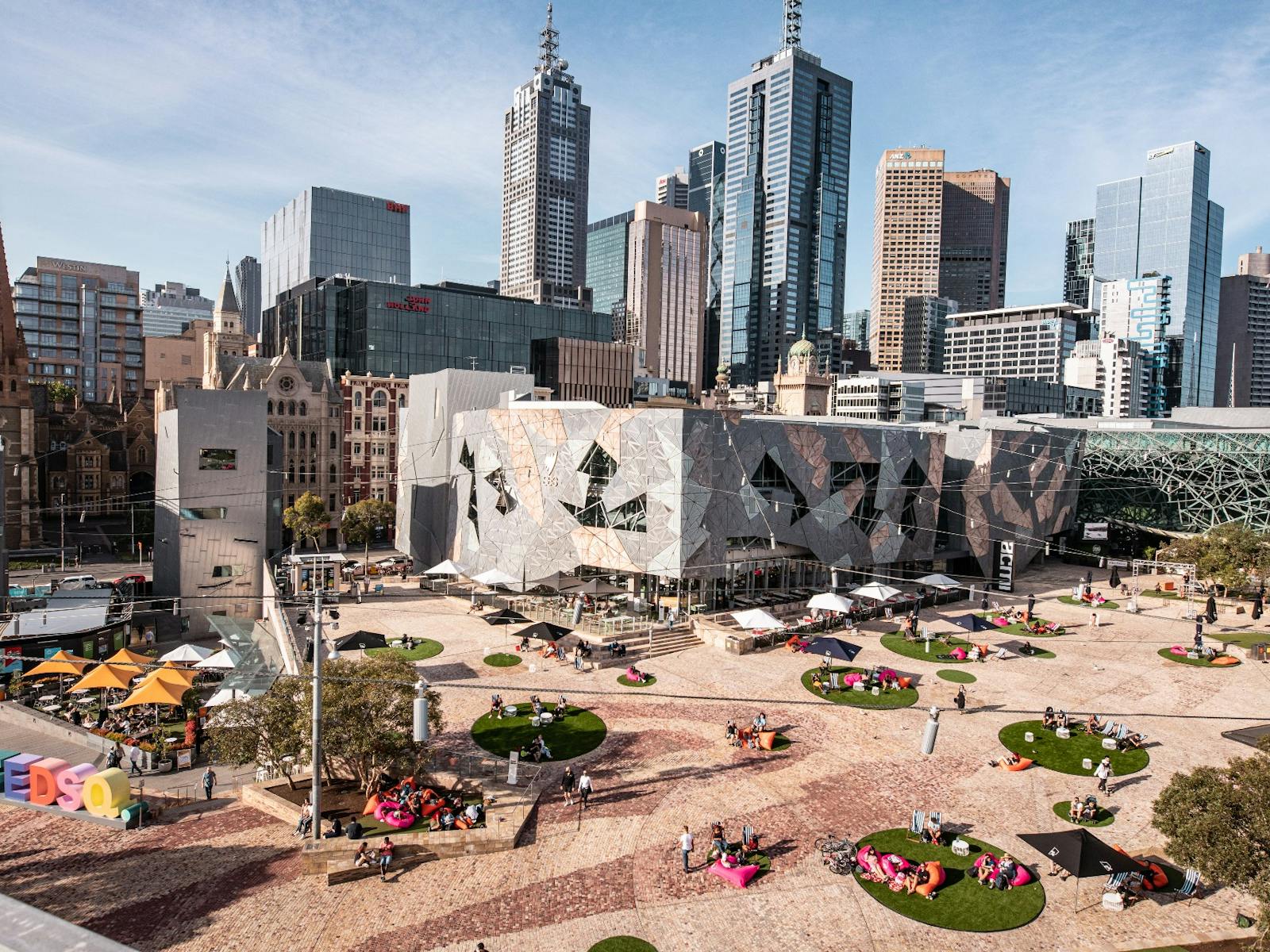 An overhead shot of Fed Square during the day. You can see the red cobblestones and unique design.