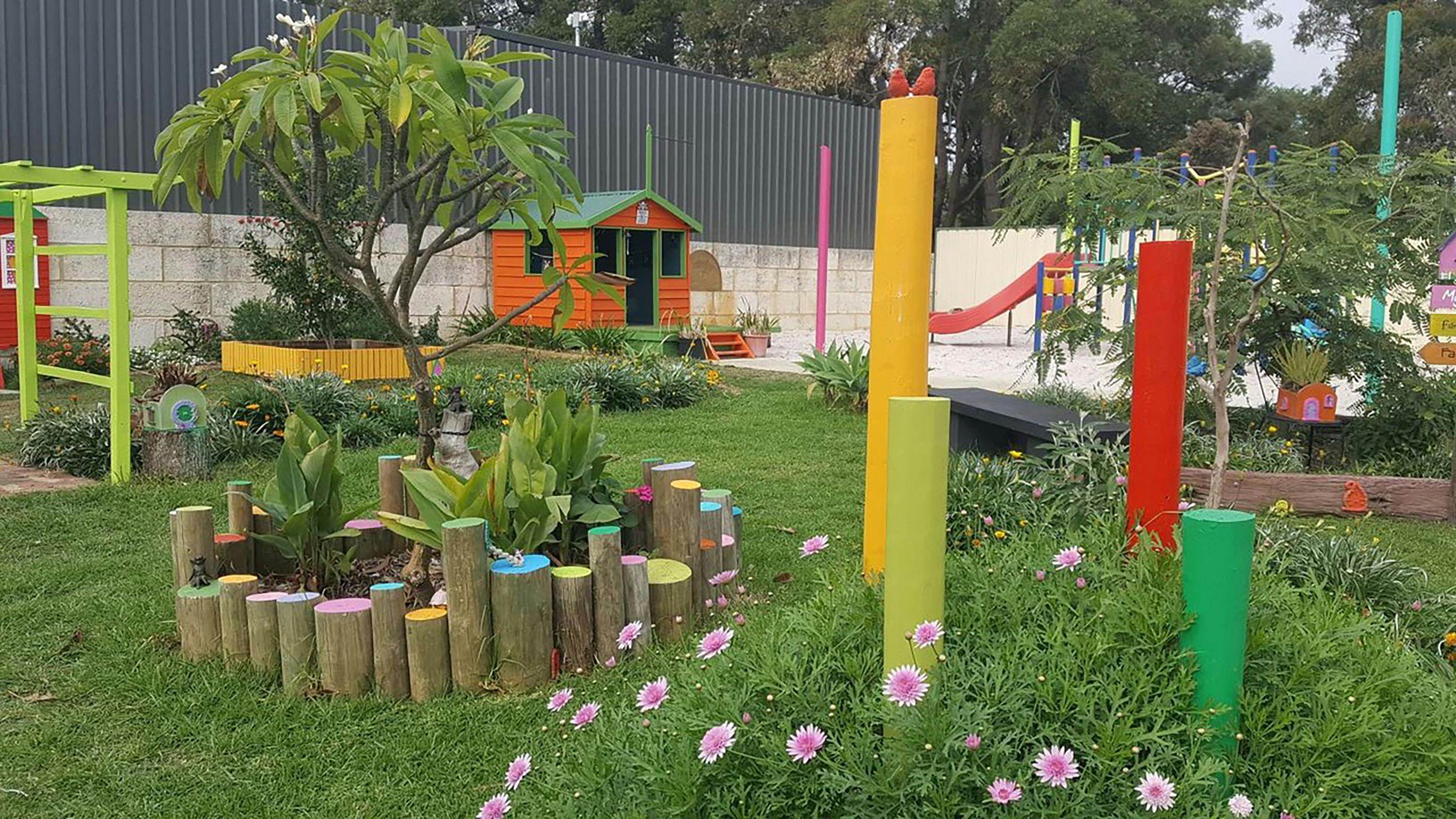 The Pirate Cubby in the background and stunning flowers in the Magic Barn Fairy Garden