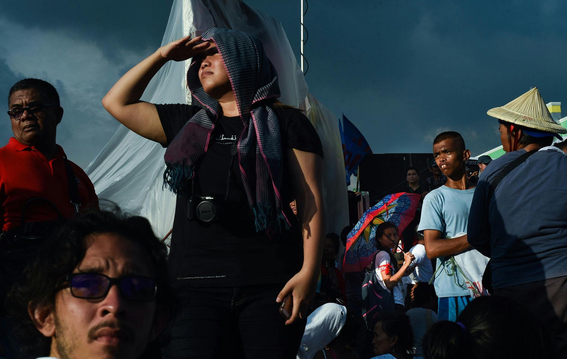 An image of multiple people in a crowd looking around in different directions