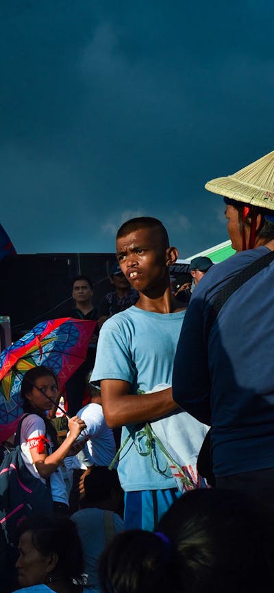 An image of multiple people in a crowd looking around in different directions