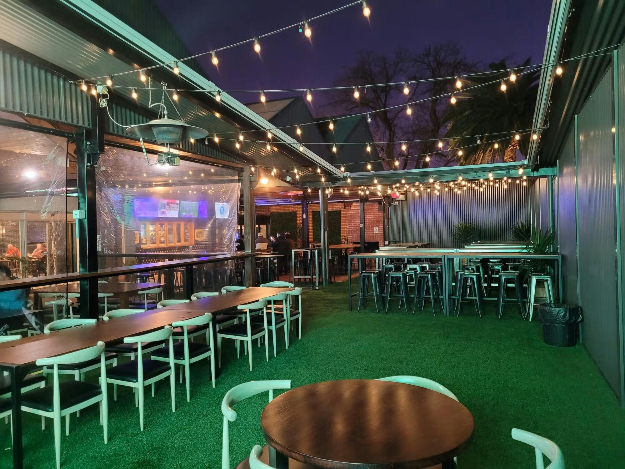 Outdoor seating area pictured at night with overhead lighting on