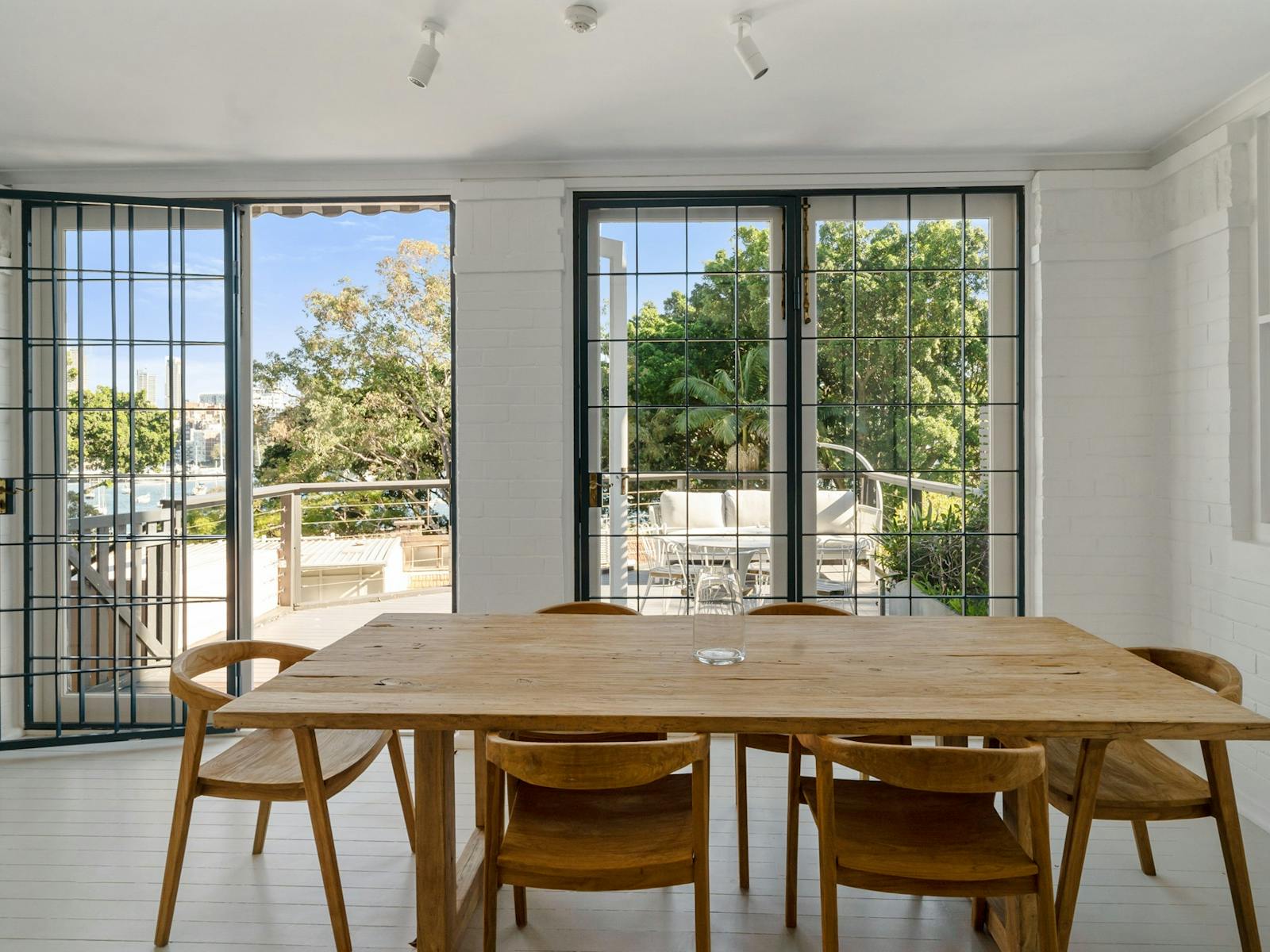 Spacious dining area with large table and open balcony view.
