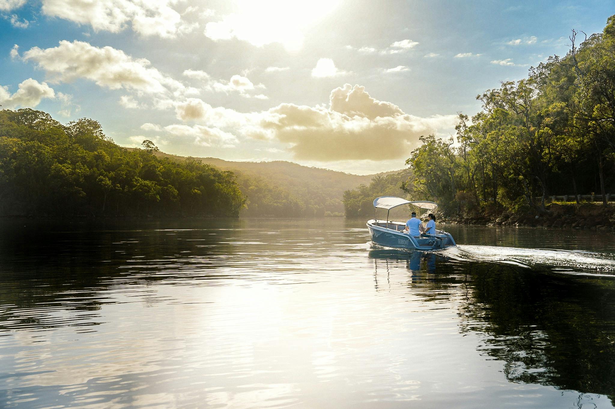Couple enjoying a GoBoat on the calm waters of Akuna Bay, Ku-ring-gai Chase National Park.