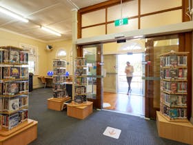 A person walks through the automatic front entry doors into a library.