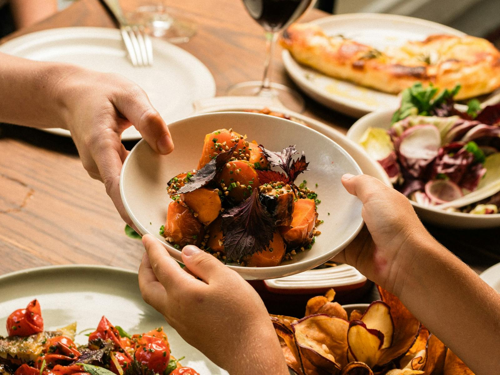 Hands passing plate of food