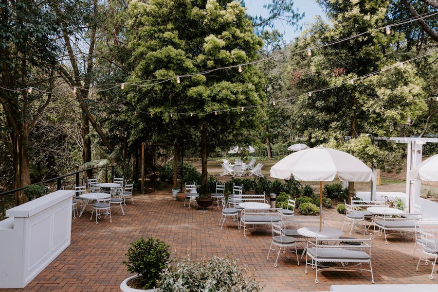 wedding garden with umbrellas, chairs and a bar