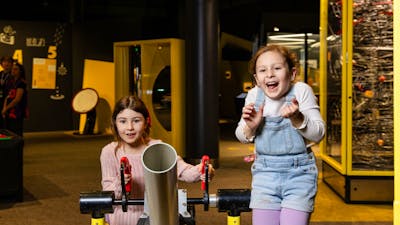 Two young girls playing with an exhibit at Questacon