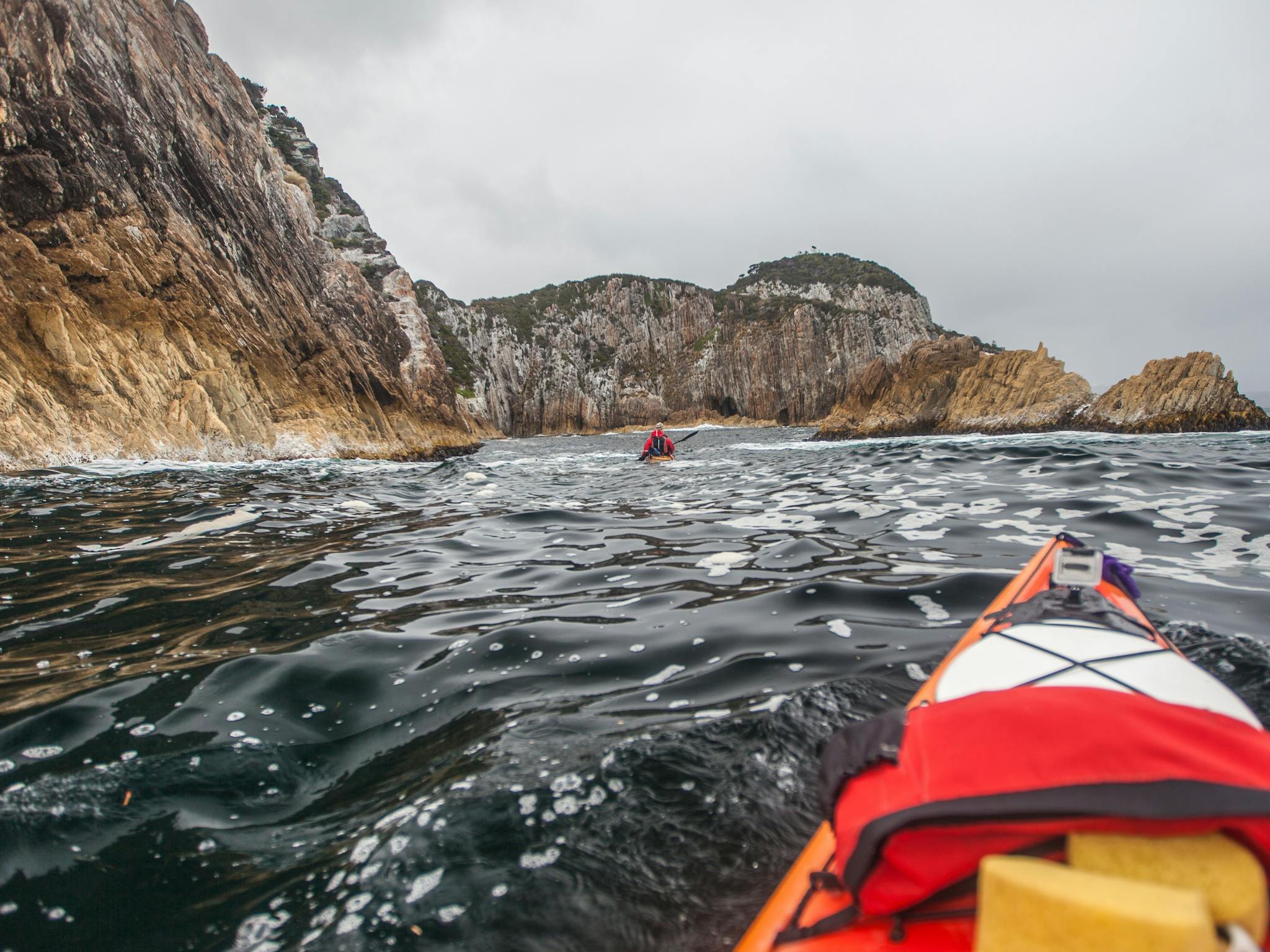 Sea kayakers paddling outside the Breaksea Islands on Port Davey in Southwest Tasmania