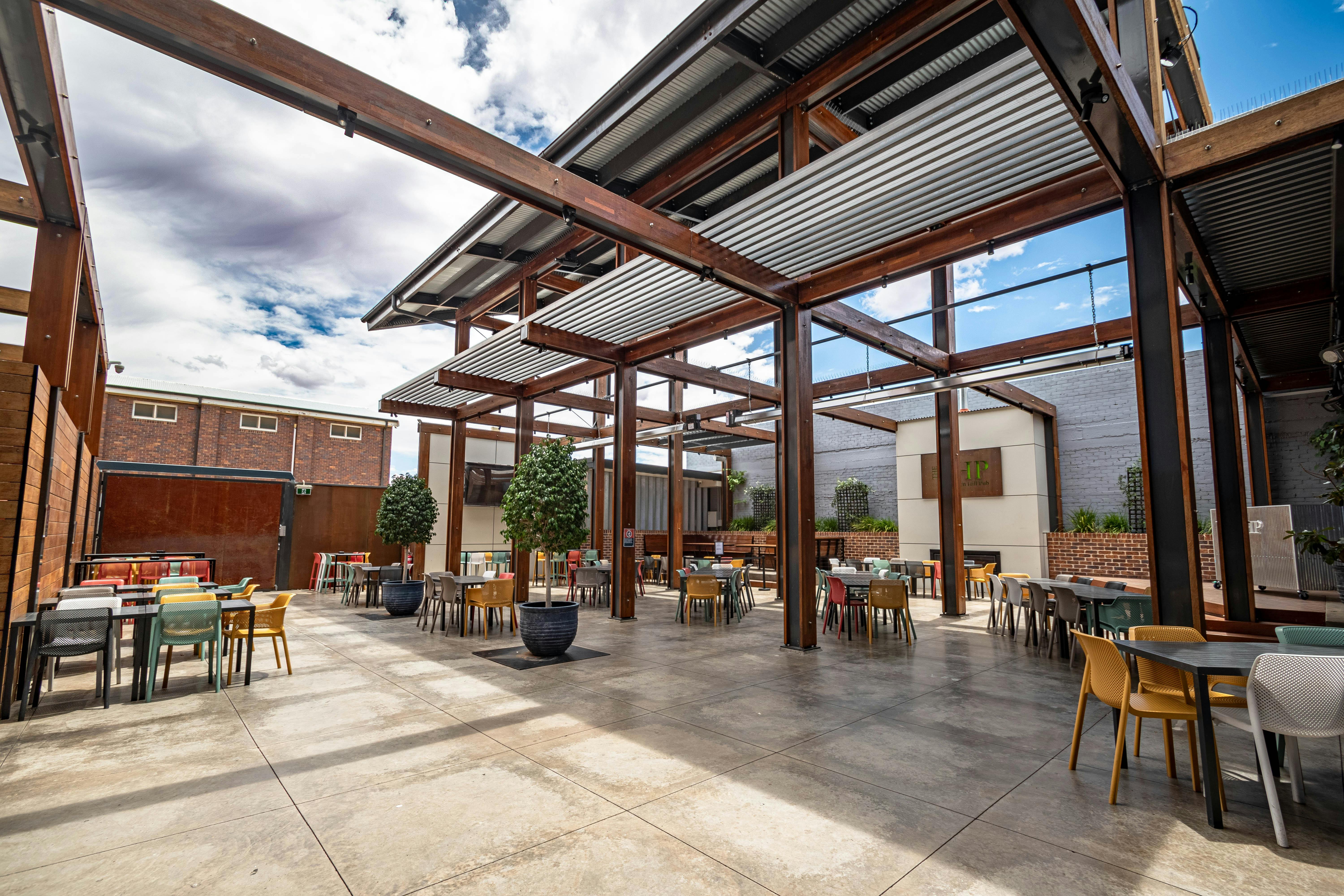 The outdoor beer garden at The Broken Hill Pub. Showing  an open outdoor area, shaded in parts.