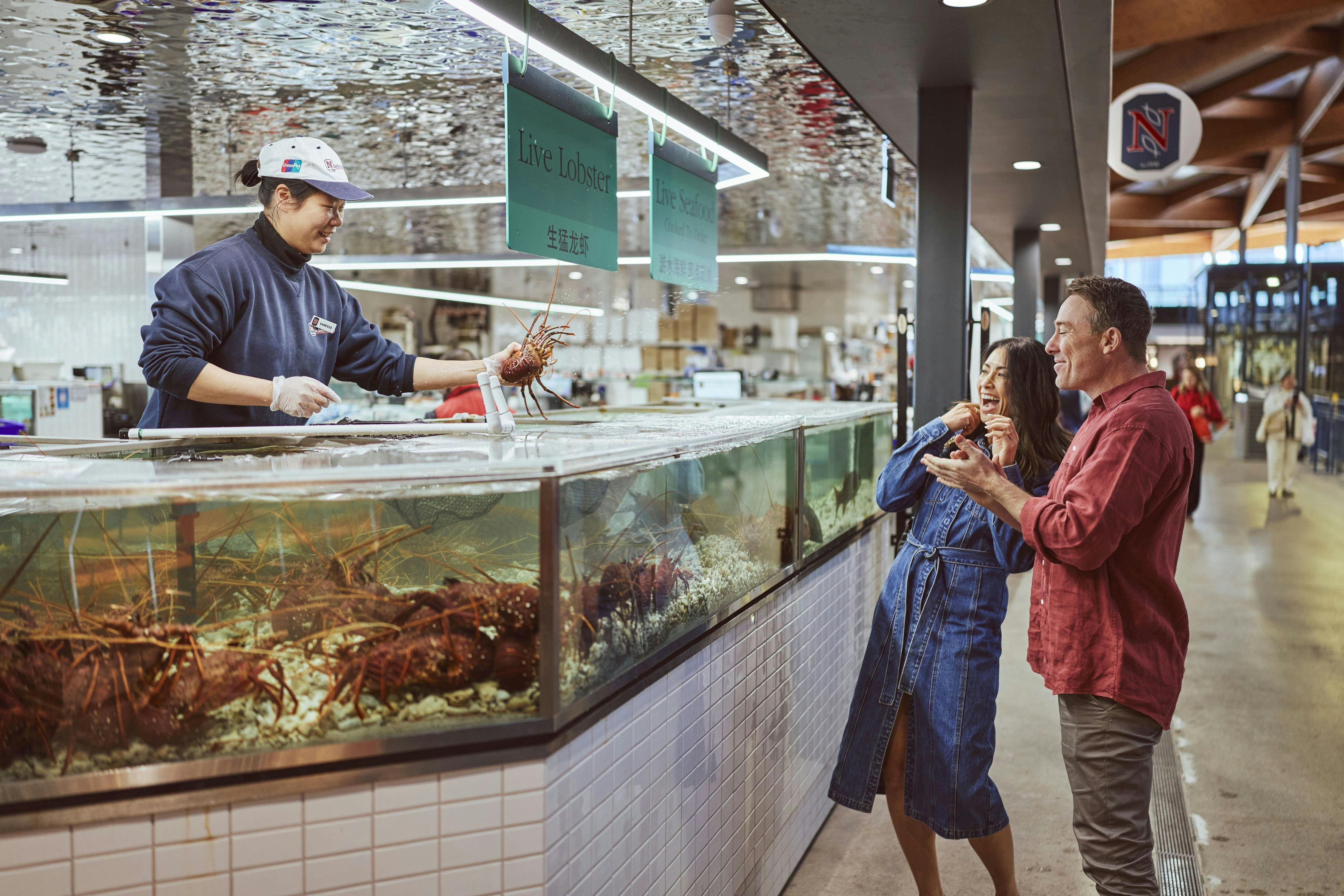 Couple looking at live lobster in a store