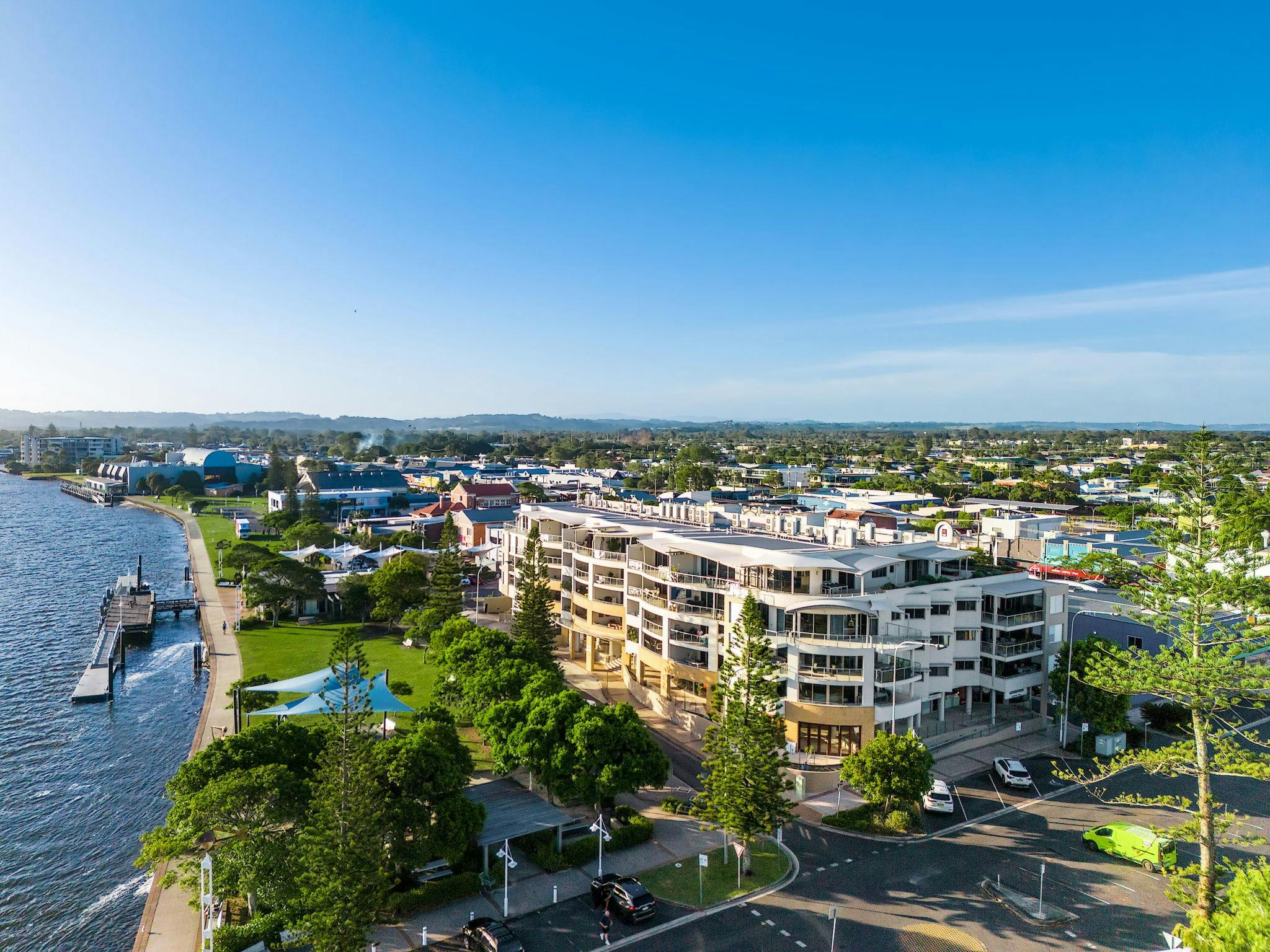 Aerial image of the apartments bordering the Richmond River with a park and wharf below